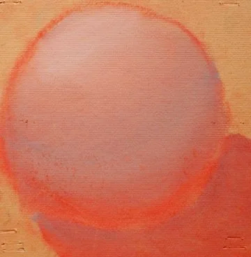 Close-up of a round, orange, and pink watercolor or pastel circle on textured paper.