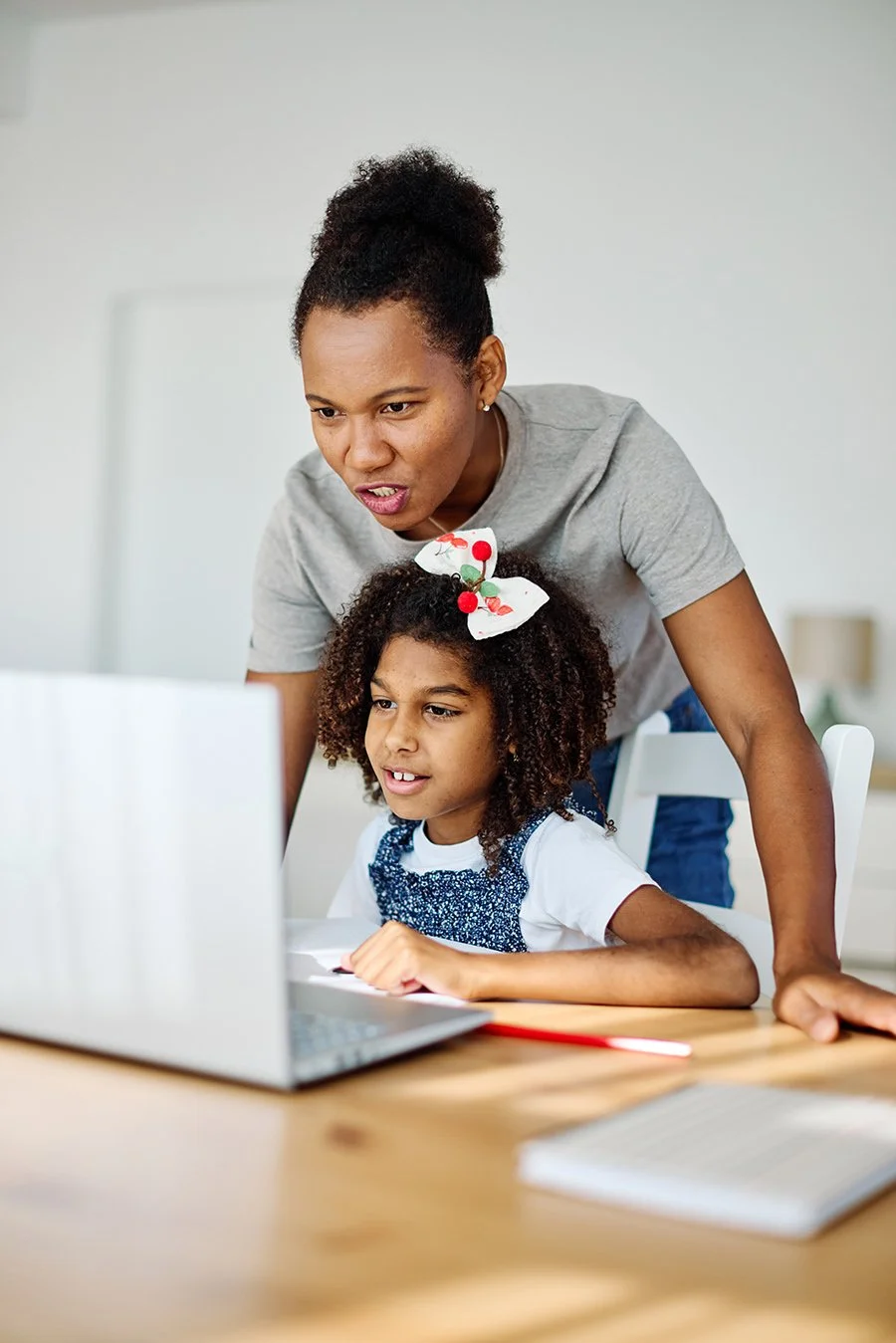 A teacher helping a young girl with dyslexia use a new Assistive Technology software program on her laptop after consultation with an Assistive Technology Practitioner in Buffalo, NY.