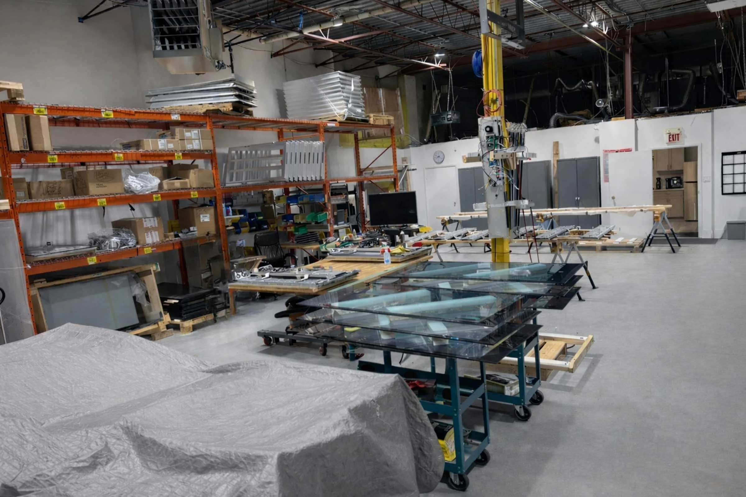 Wide view of B&F Solutions Inc’s manufacturing floor with indoor digital signage components staged for assembly and finishing.