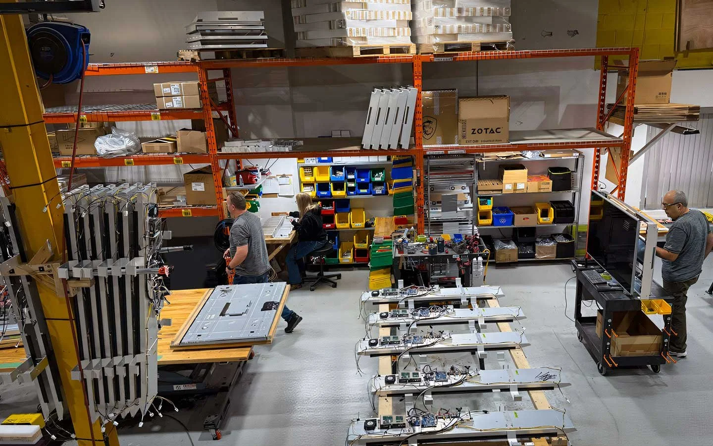 Wide view of B&F Solutions Inc’s production floor with multiple indoor digital signage units in active assembly.