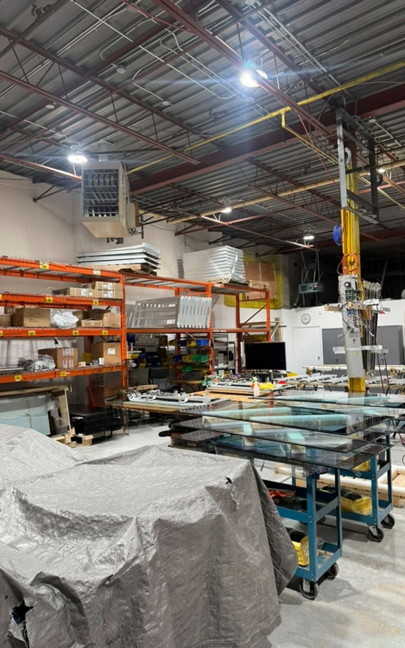 Tempered glass panels staged on carts for indoor digital signage systems at B&F Solutions Inc.