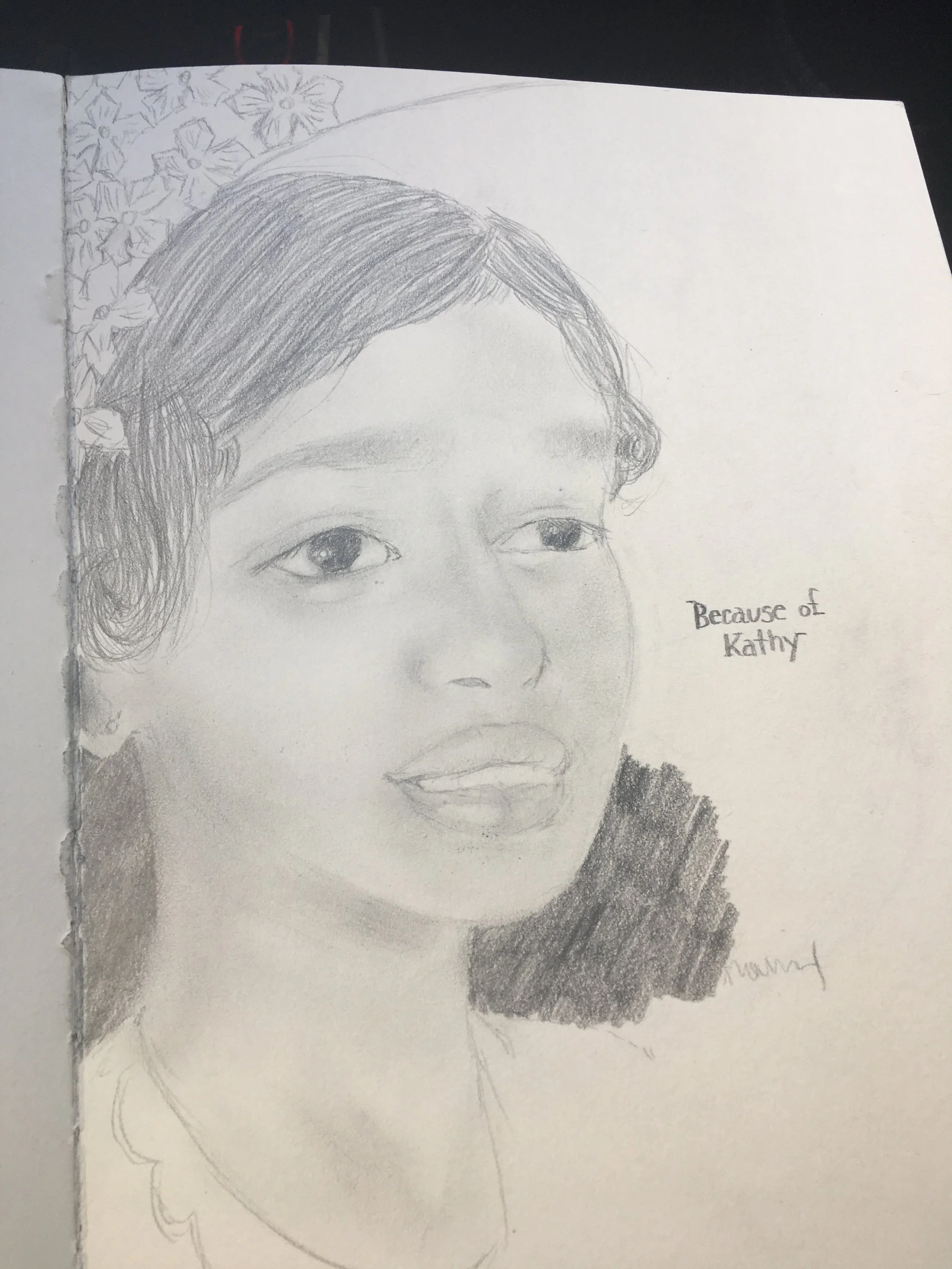 Pencil sketch of a young woman with dark hair, smiling slightly, with flowers in the background and the text 'Because of Kathy' written on the side.