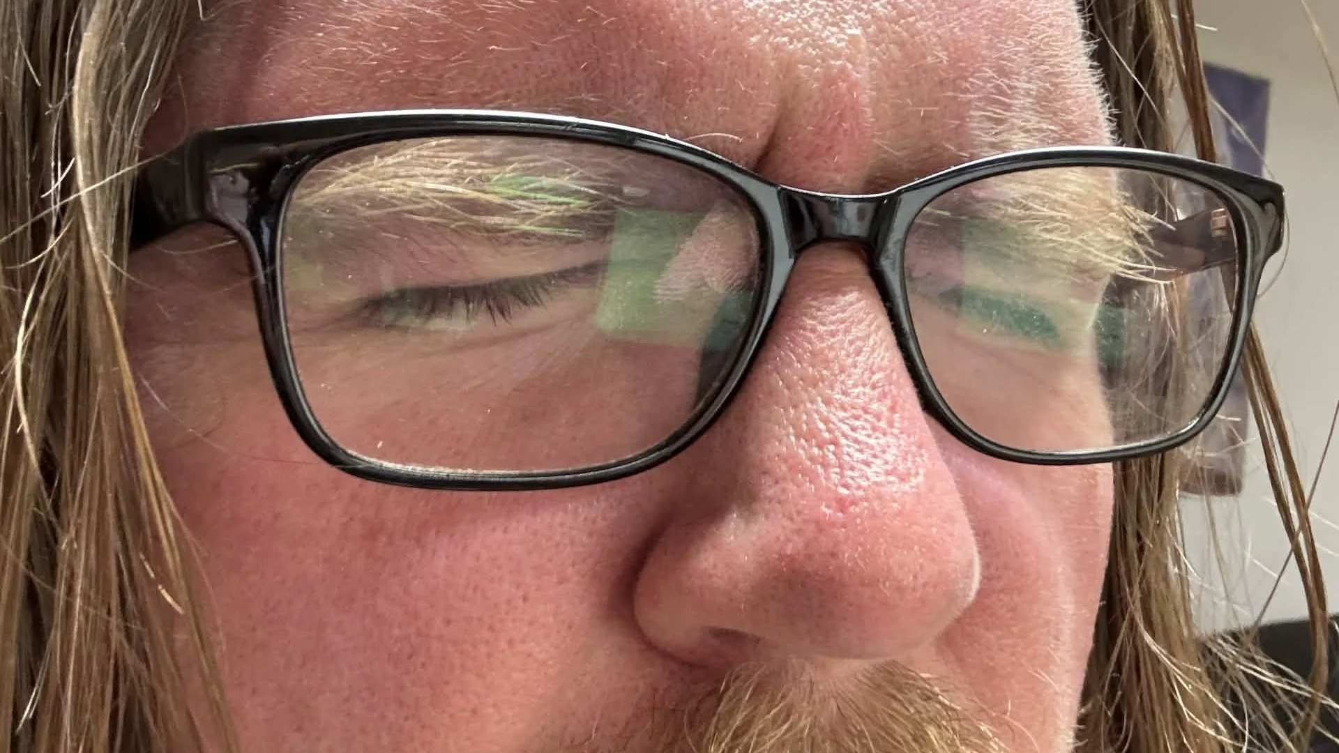 Guy in glasses with his eyes closed.