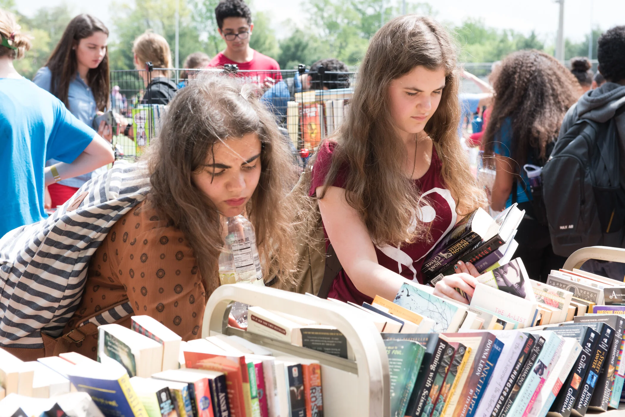 People browsing books at an outdoor book sale.