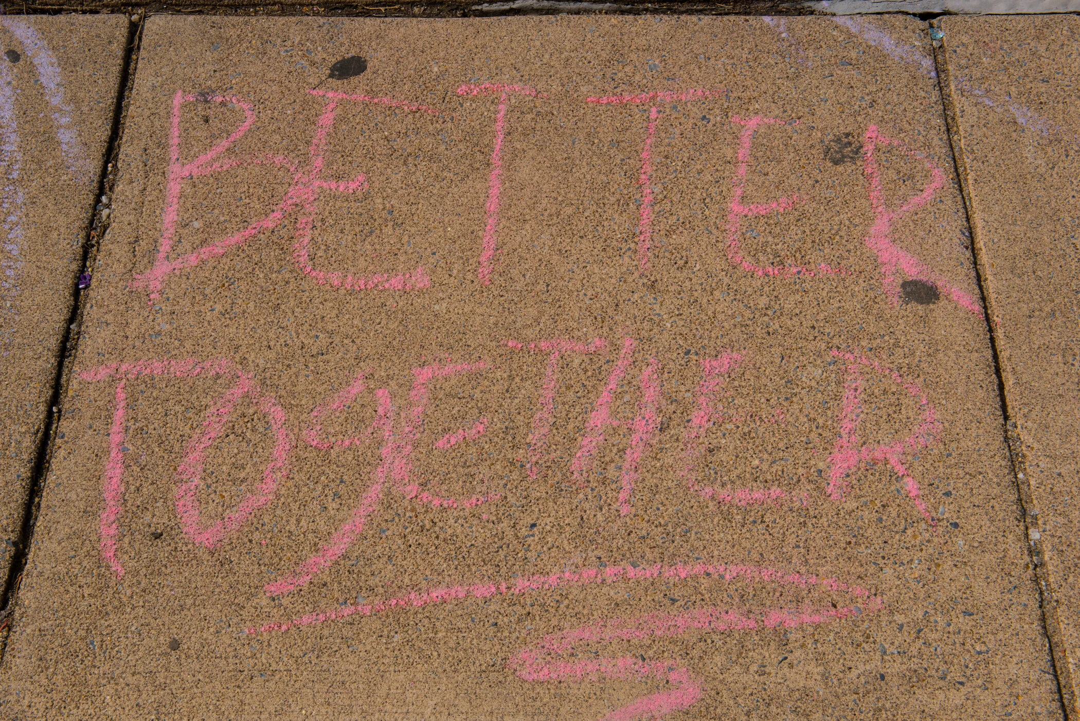 Pink chalk message on concrete sidewalk that reads "BE PREPARED".