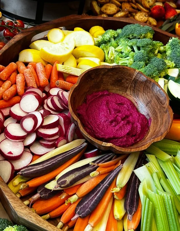 Assorted fresh vegetables including carrots, radishes, beets, broccoli, zucchini, eggplant, celery, and yellow squash.