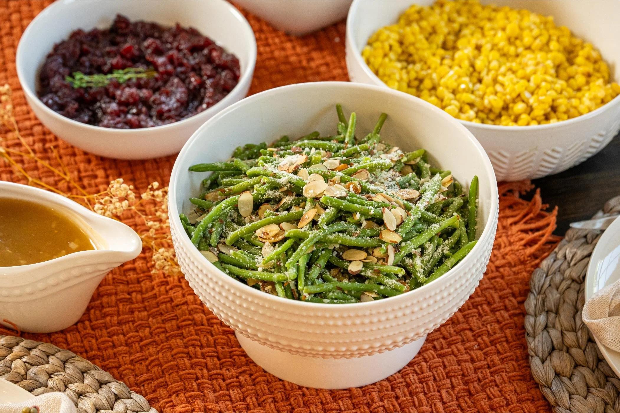 Holiday Feast group Thanksgiving catering spread with cranberry sauce, green beans almondine, corn and gravy