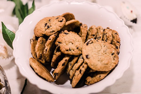 A white bowl filled with chocolate chip cookies on a table.