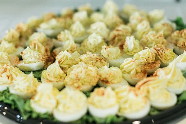 Deviled eggs with mayonnaise-based filling on a tray.