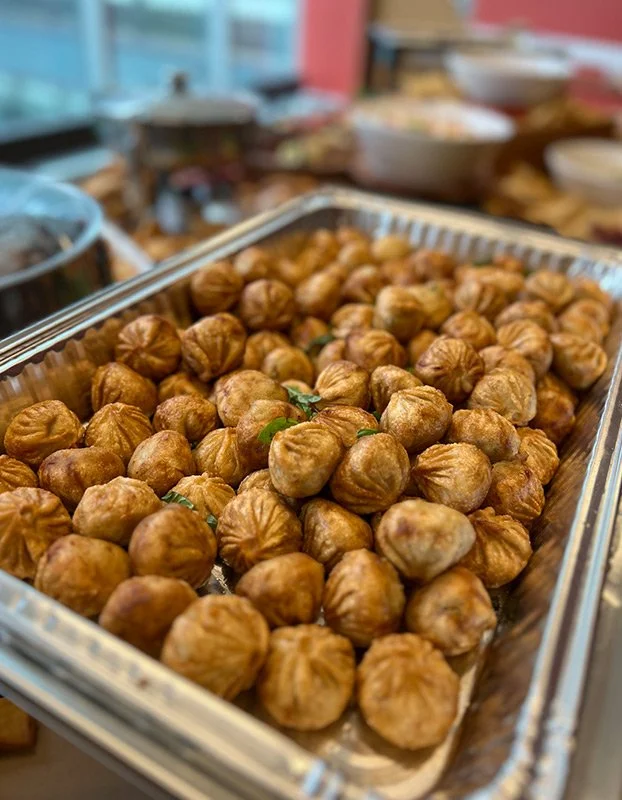 Tray of roasted chickpeas on a table, with bowls and kitchen items in the background.