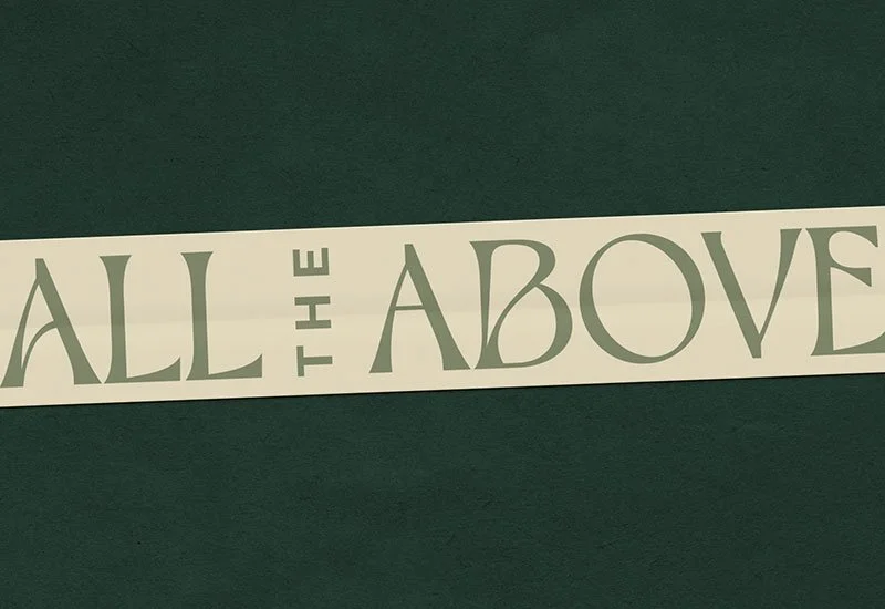 Close-up of a white sticker tape with All the Above wordmark on a dark green background.