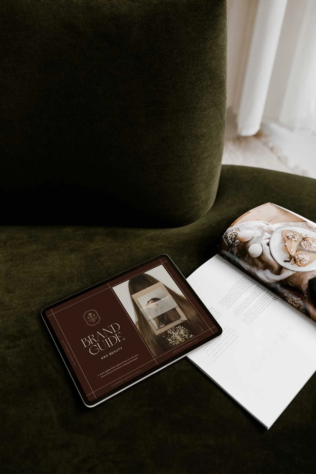 A tablet displaying a brand guide for a beauty brand resting on a luxurious green sofa