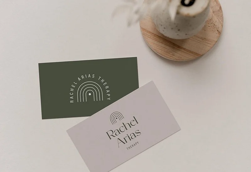 Business card for Rachel Arias Therapy and a green logo card with an arch rainbow design