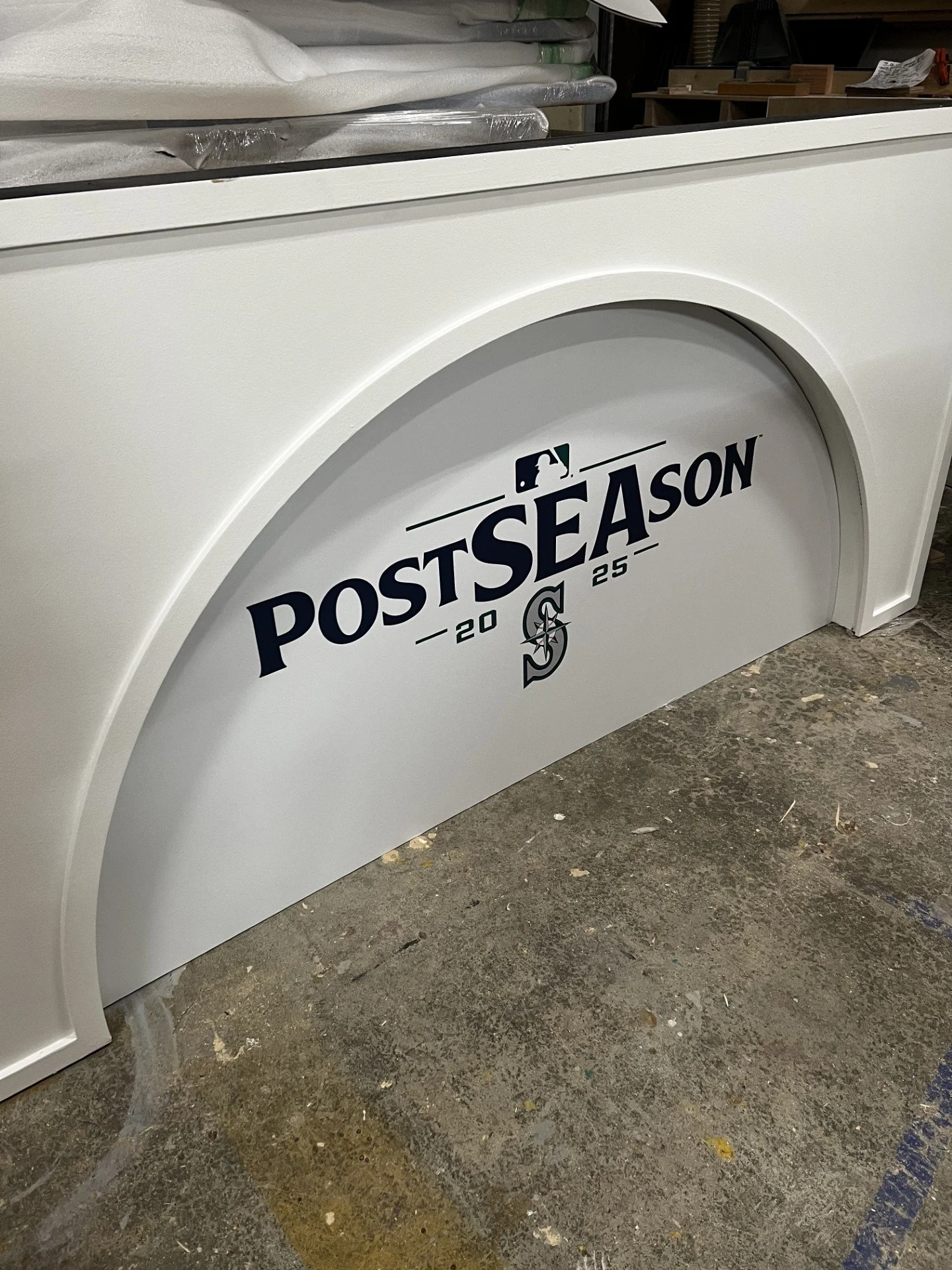 A white decorative piece with the Seattle Mariners' 2025 postseason logo, featuring the text 'POSTSEASON' with '20' and '25' on either side and the Mariners' compass logo underneath.