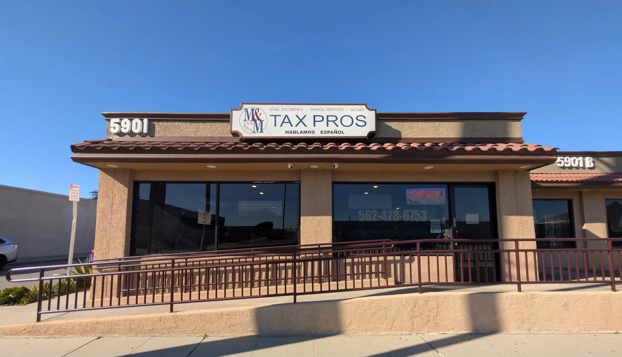 Front view of a beige building with red roof tiles, a sign that reads 'Tax Pros,' and large windows. The building has addresses 5901 and 5901B, and a wheelchair accessible ramp.
