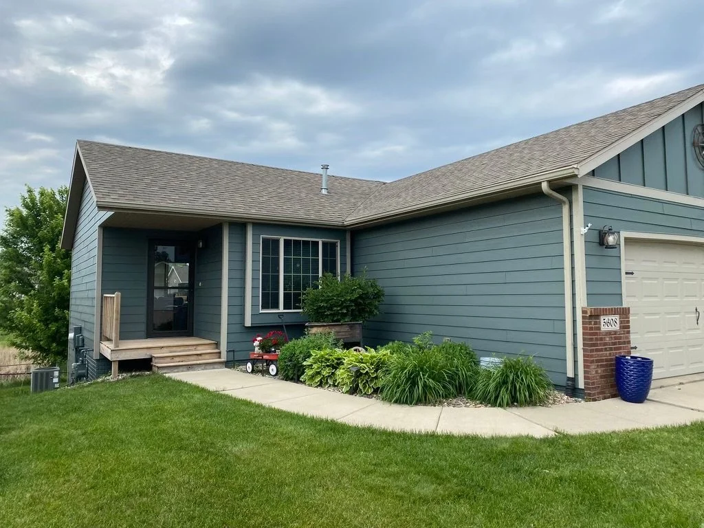 Exterior photo of a home with blue siding and white trim