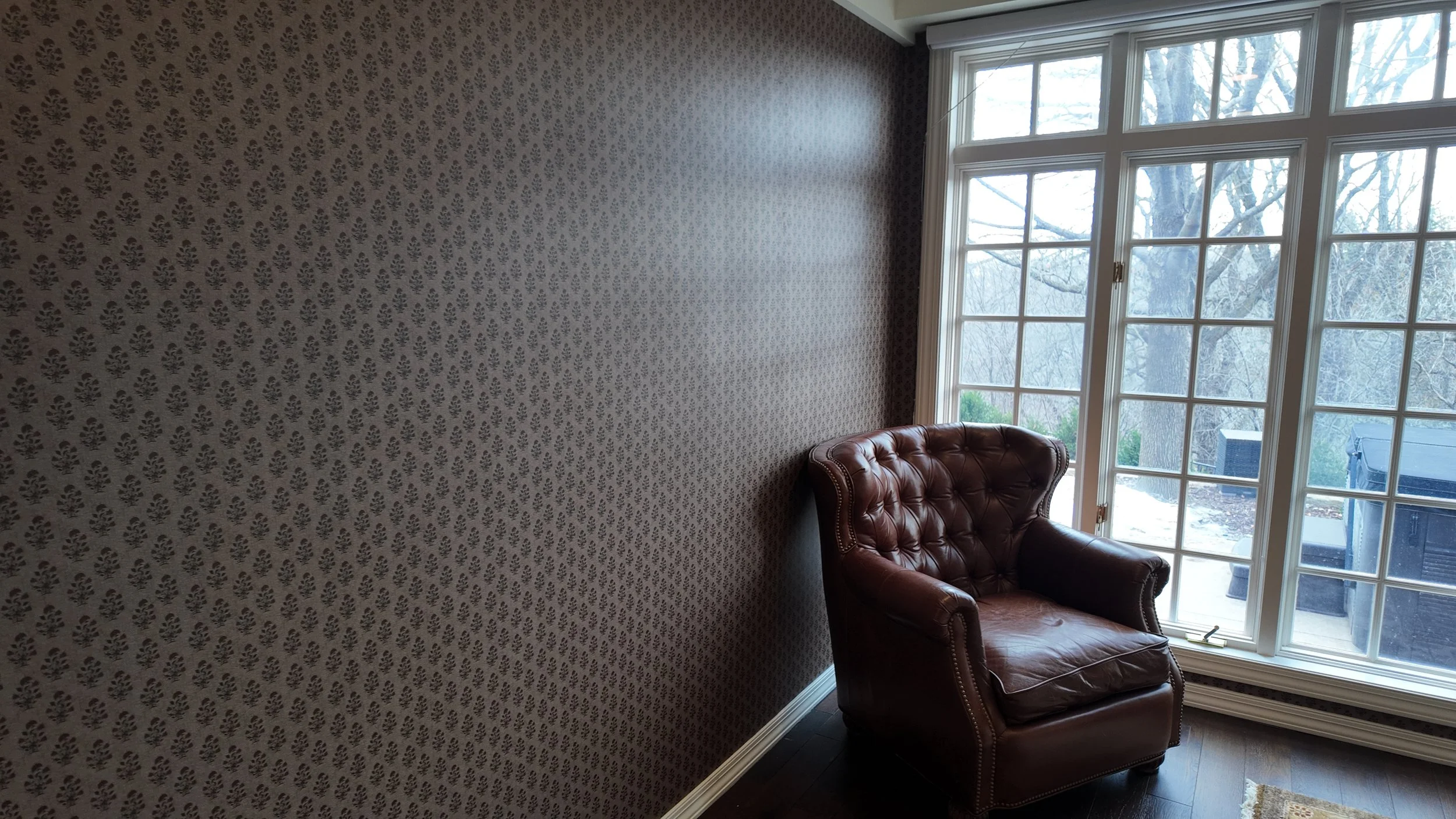 Elegant room in home with wallpaper on one wall and windows on the other