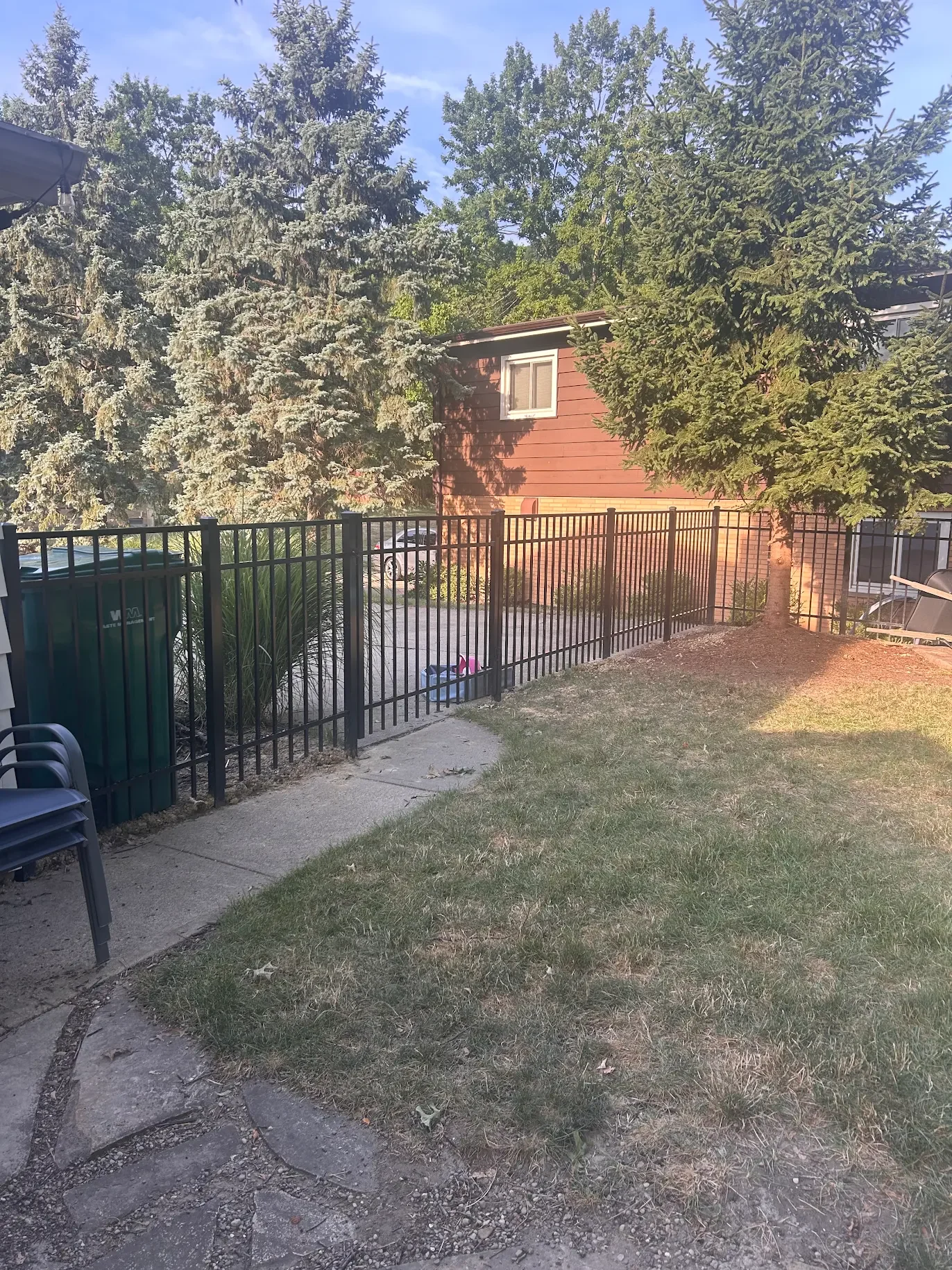Black aluminum fence along backyard sidewalk of Cleveland residential property.