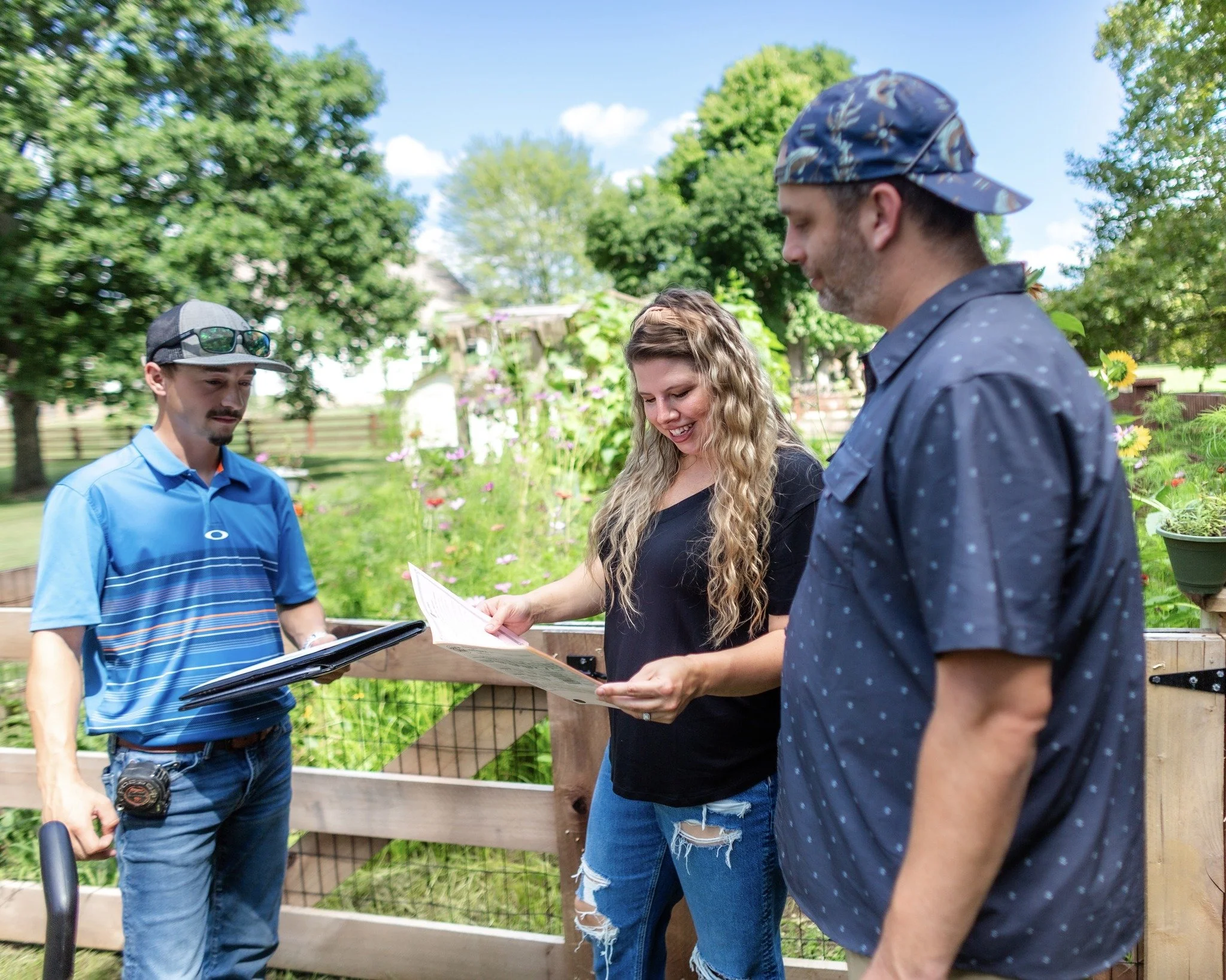 Mae Fence Manager, Mason looking over a free fence estimate with two customers