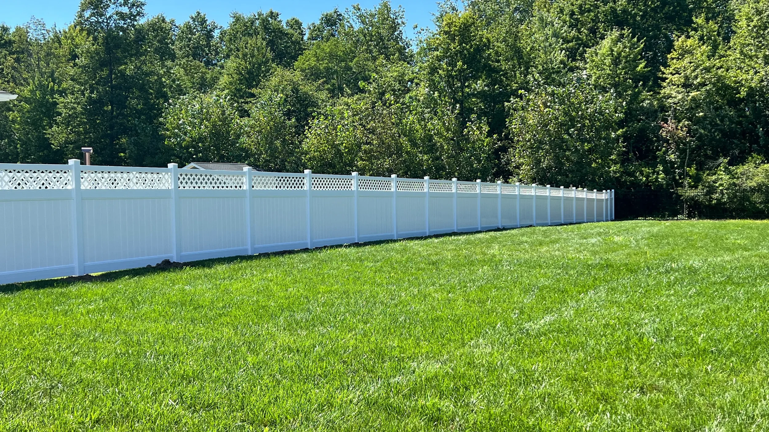 White vinyl privacy fence with decorative lattice around a Cleveland home backyard