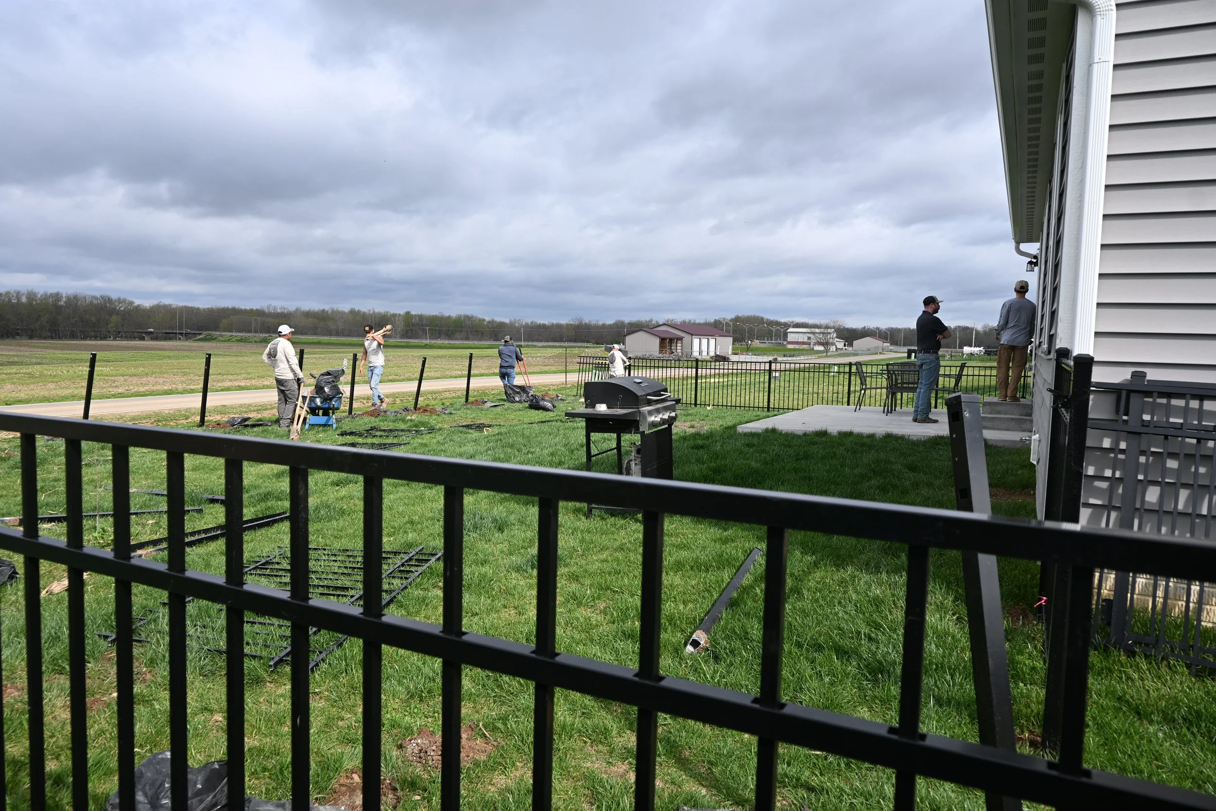 Black aluminum fence being installed around a residential property backyard in Dayton, Ohio
