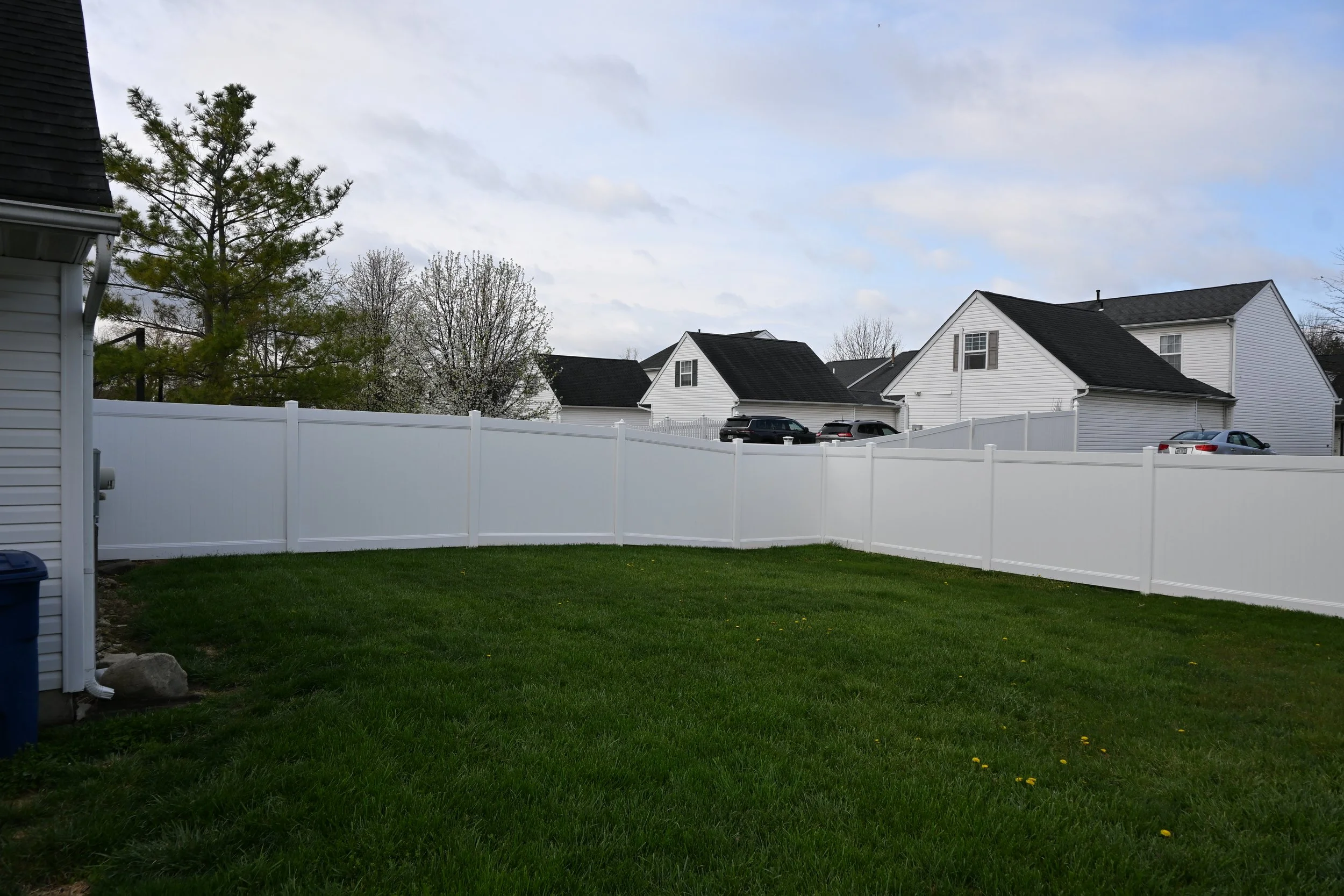White vinyl privacy fence around residential backyard