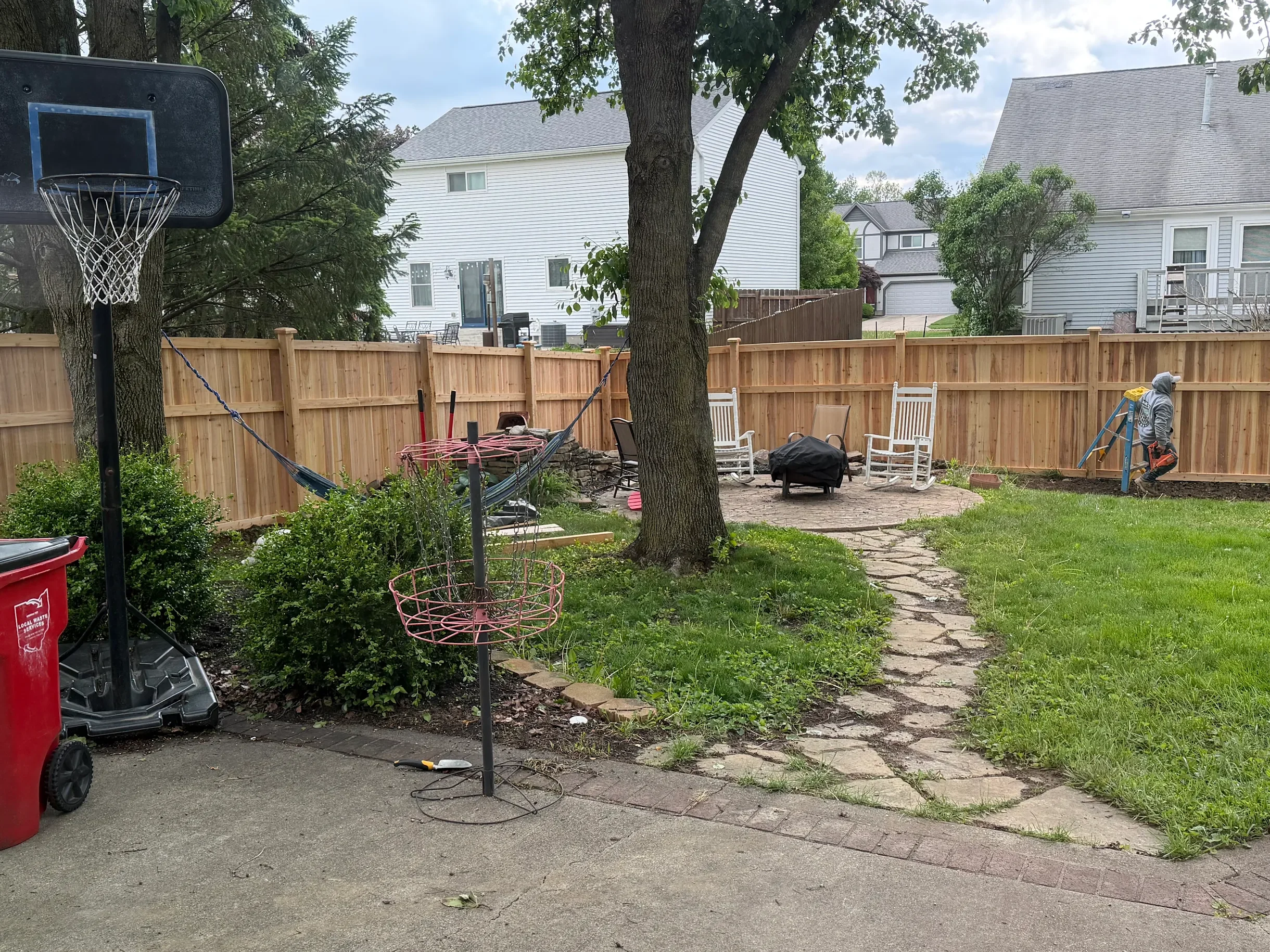 Traditional cedar privacy fence around a backyard with Cincinnati neighborhood houses behind it.