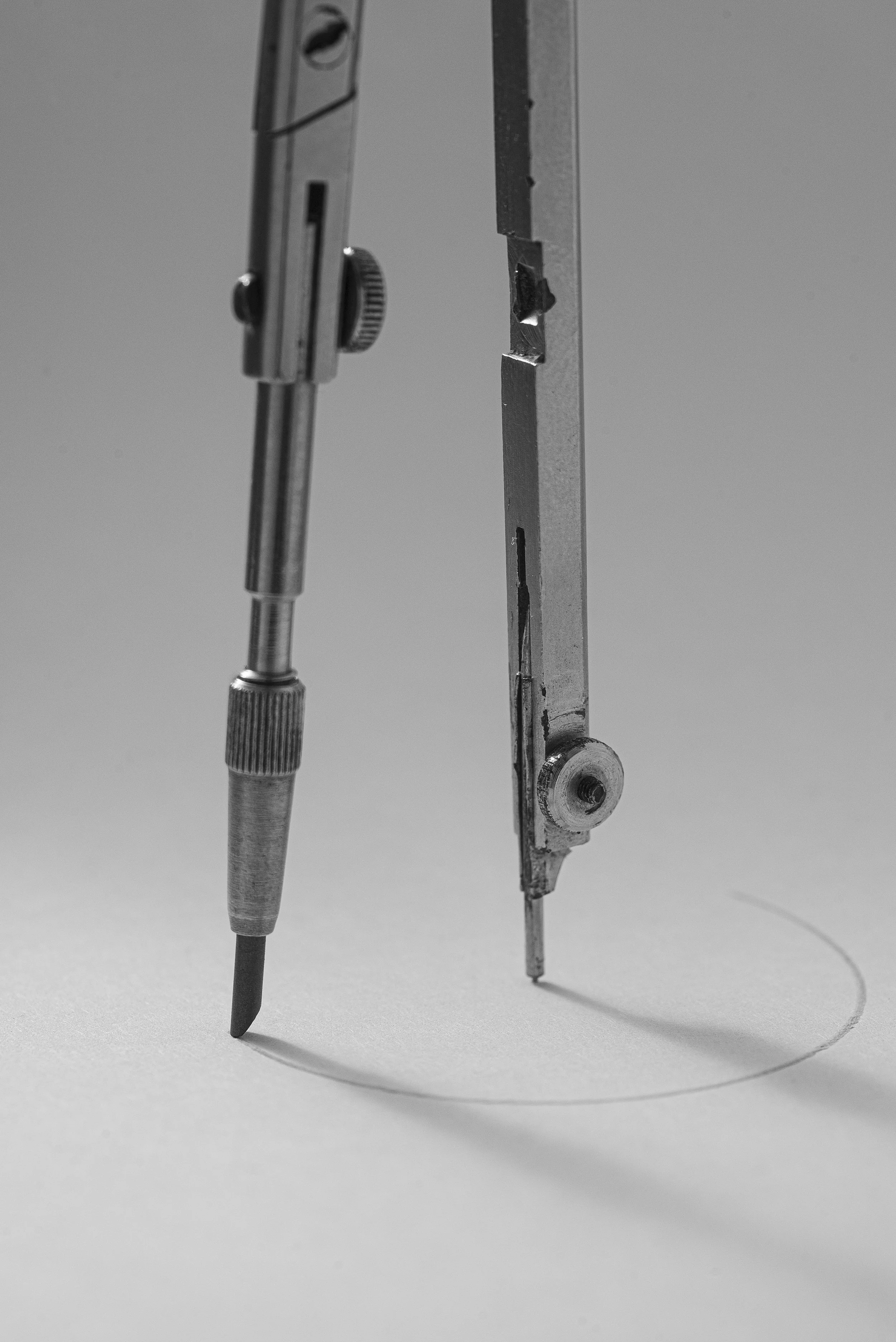 black and white photo of precision tool compass drawing a circle