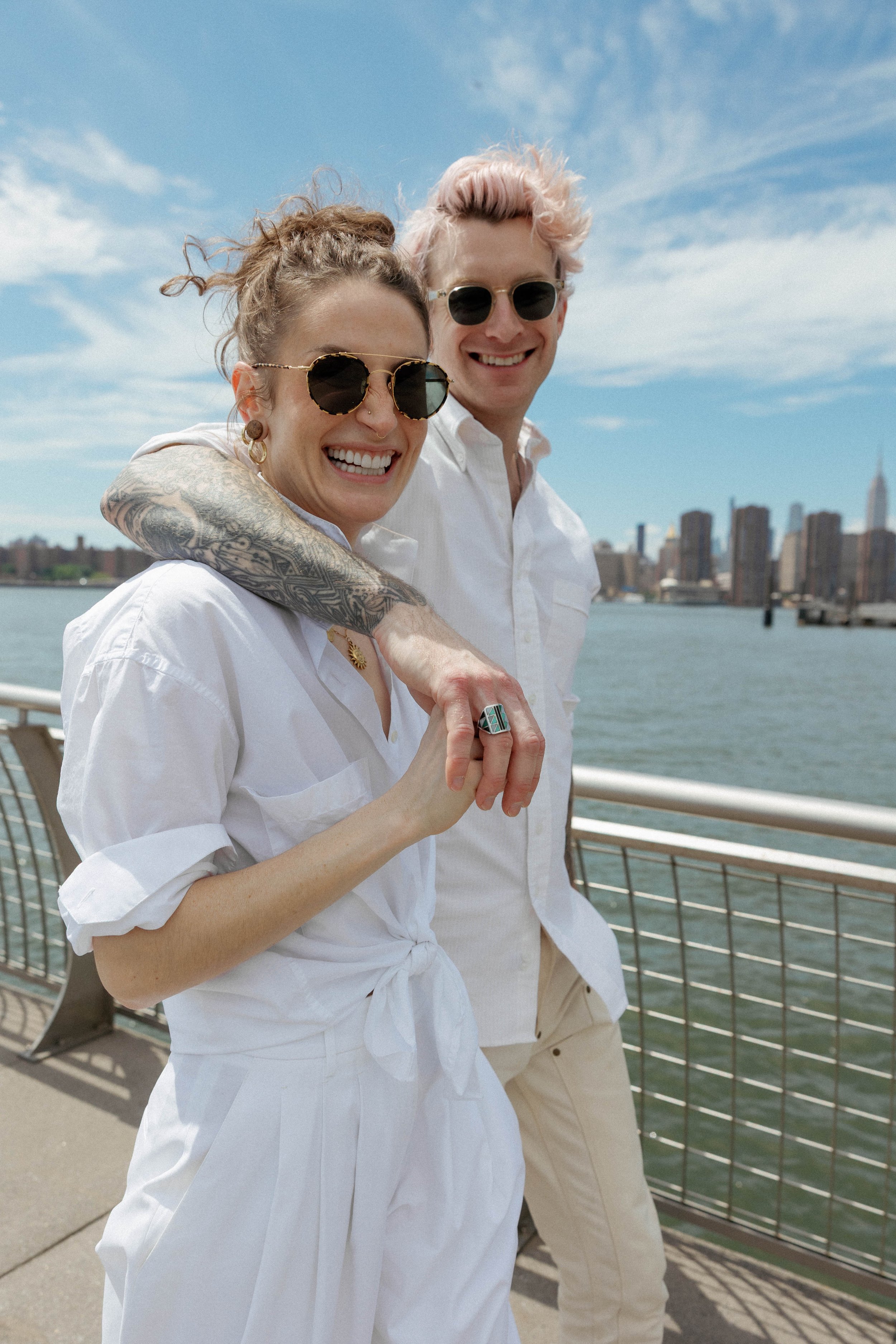 couple in white shirts holding hands on a bridge