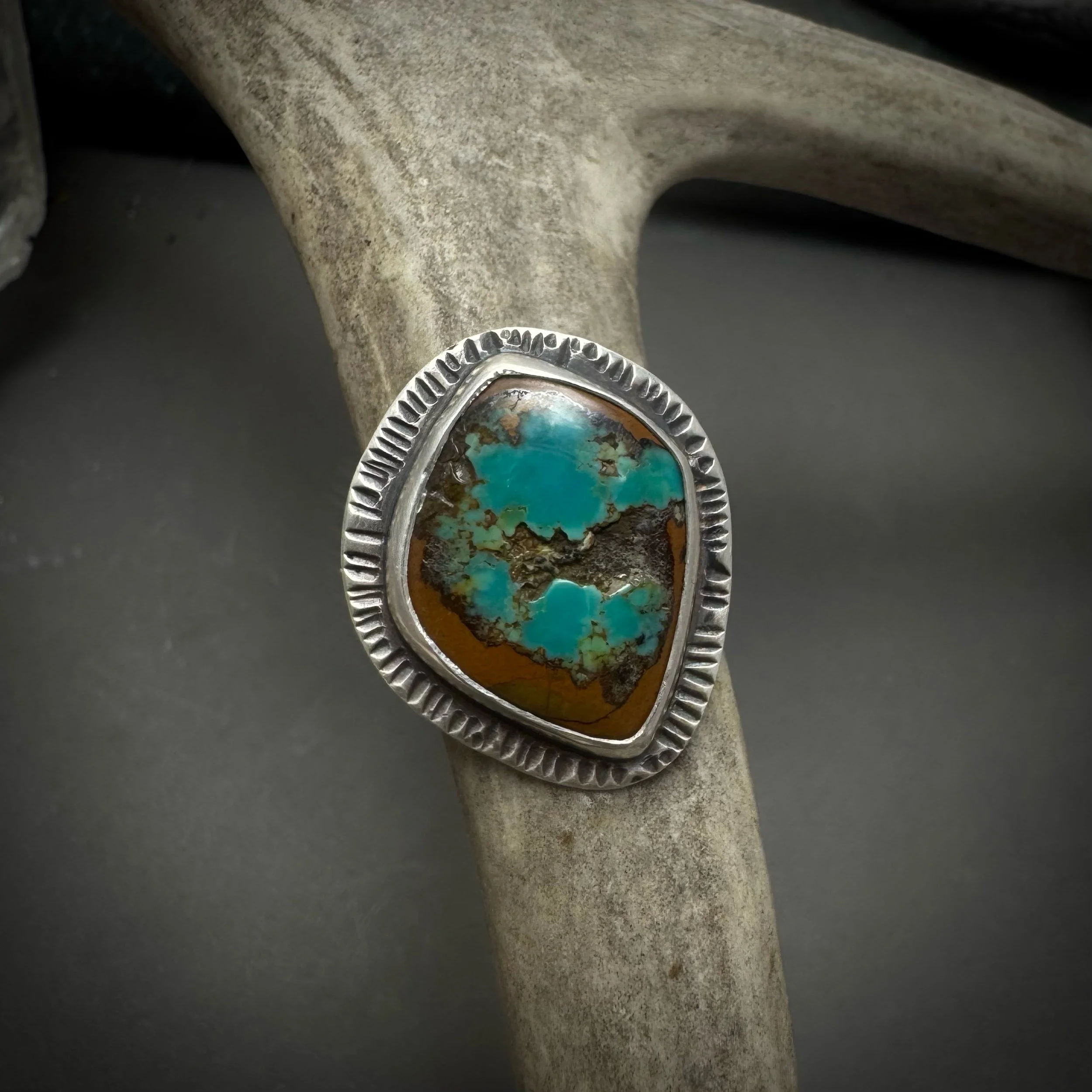 Sterling silver ring with rough turquoise cabochon and radial textured setting