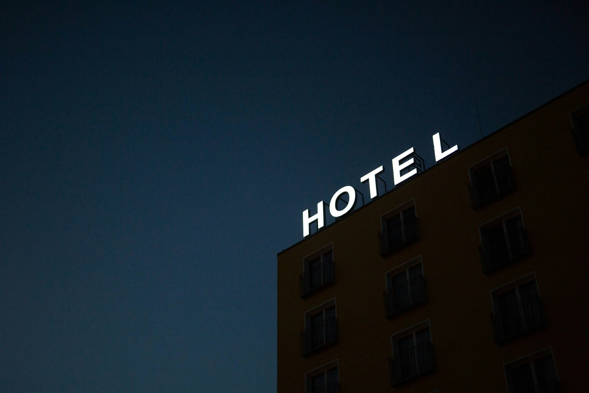 Le signe lumineux 'HOTEL' sur le toit d'un bâtiment résidentiel, la nuit.