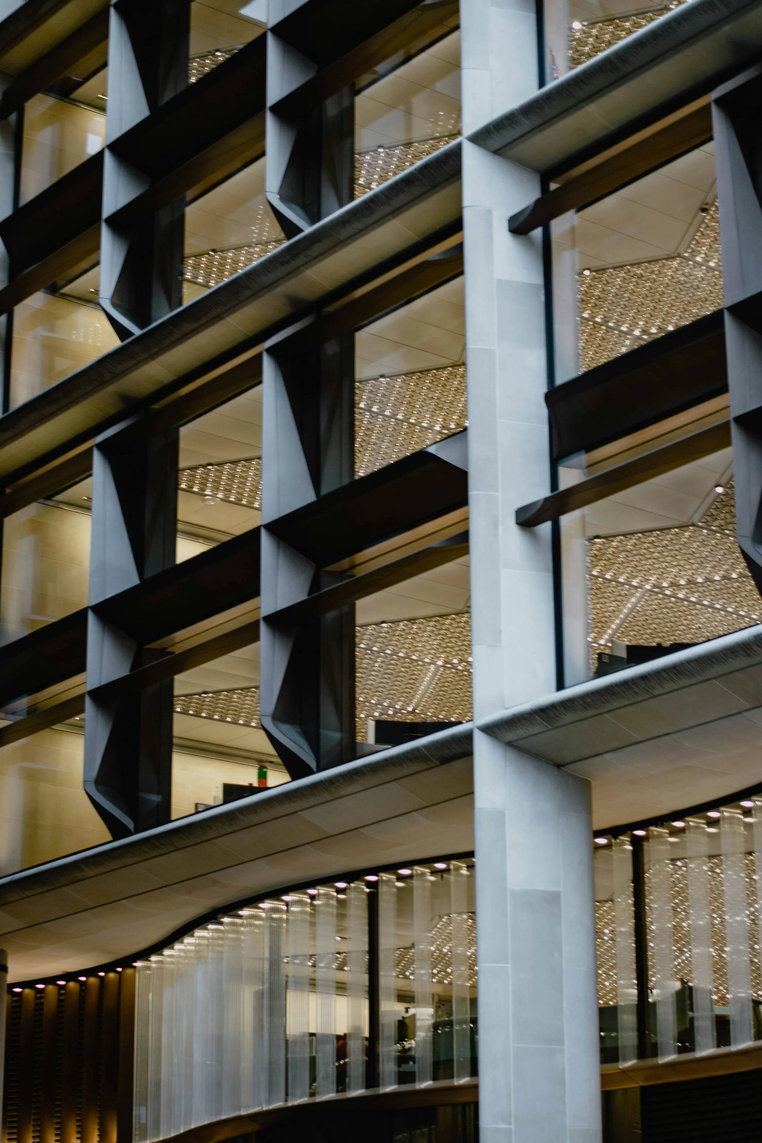 Vue d'un bâtiment moderne avec plusieurs étages visibles, façonné avec des structures en acier et des fenêtres en verre, accentuant un design contemporain et architectural innovant.