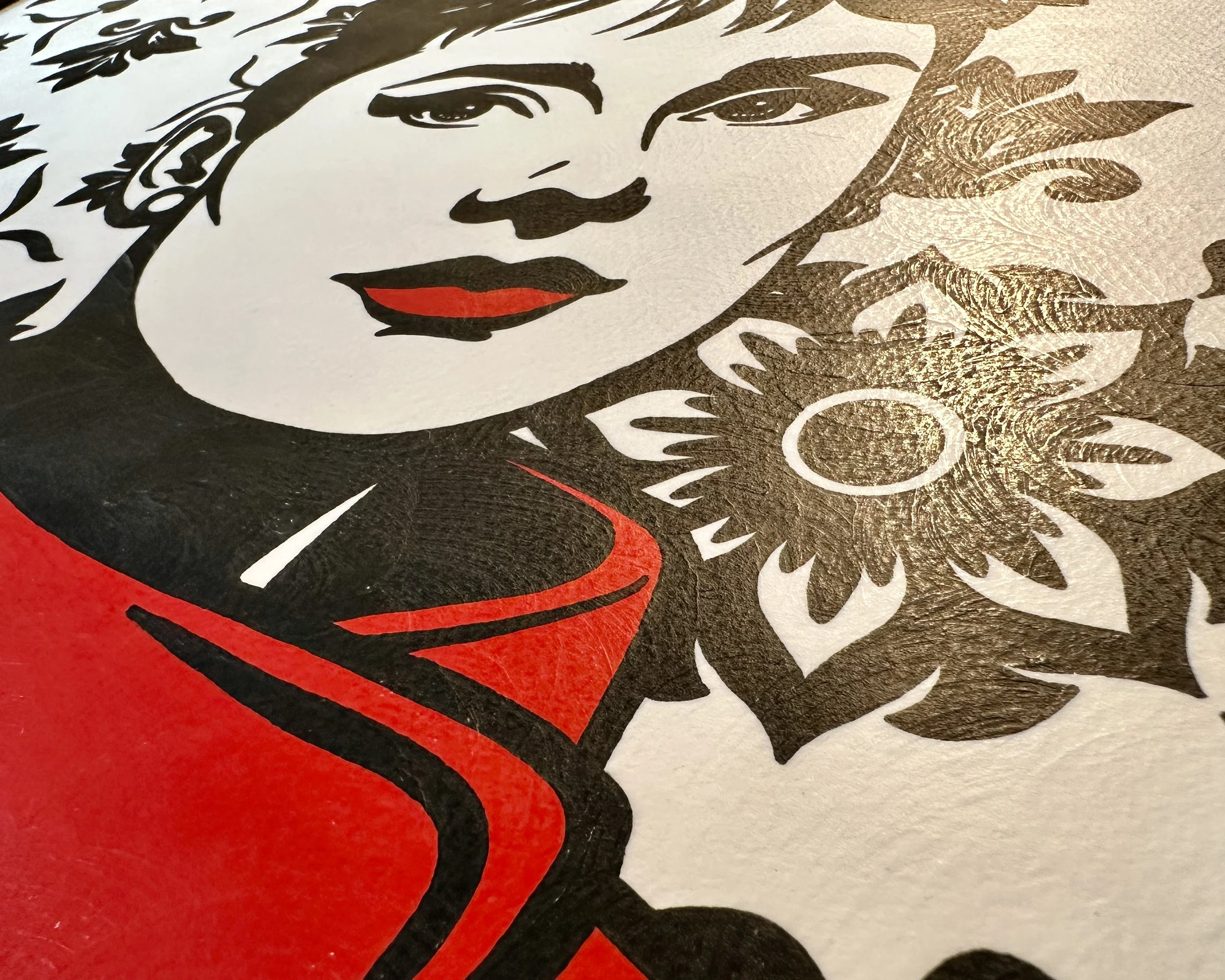 Original framed painting titled Audrey in Red featuring a pop art portrait of Audrey Hepburn in profile with large earrings and a red dress against a geometric pattern by Omaha artist.