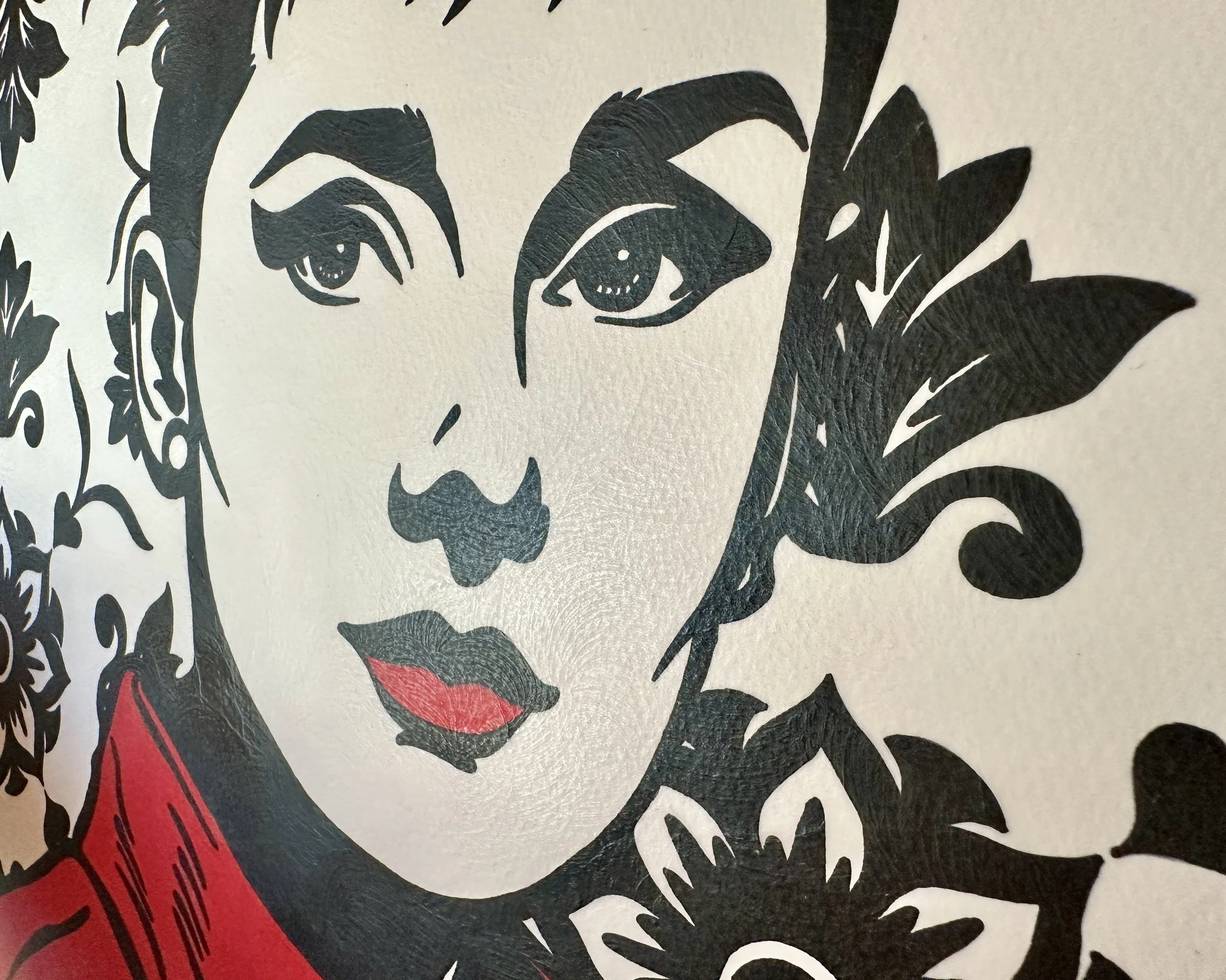 Original framed painting titled Audrey in Red featuring a pop art portrait of Audrey Hepburn in profile with large earrings and a red dress against a geometric pattern by Omaha artist.