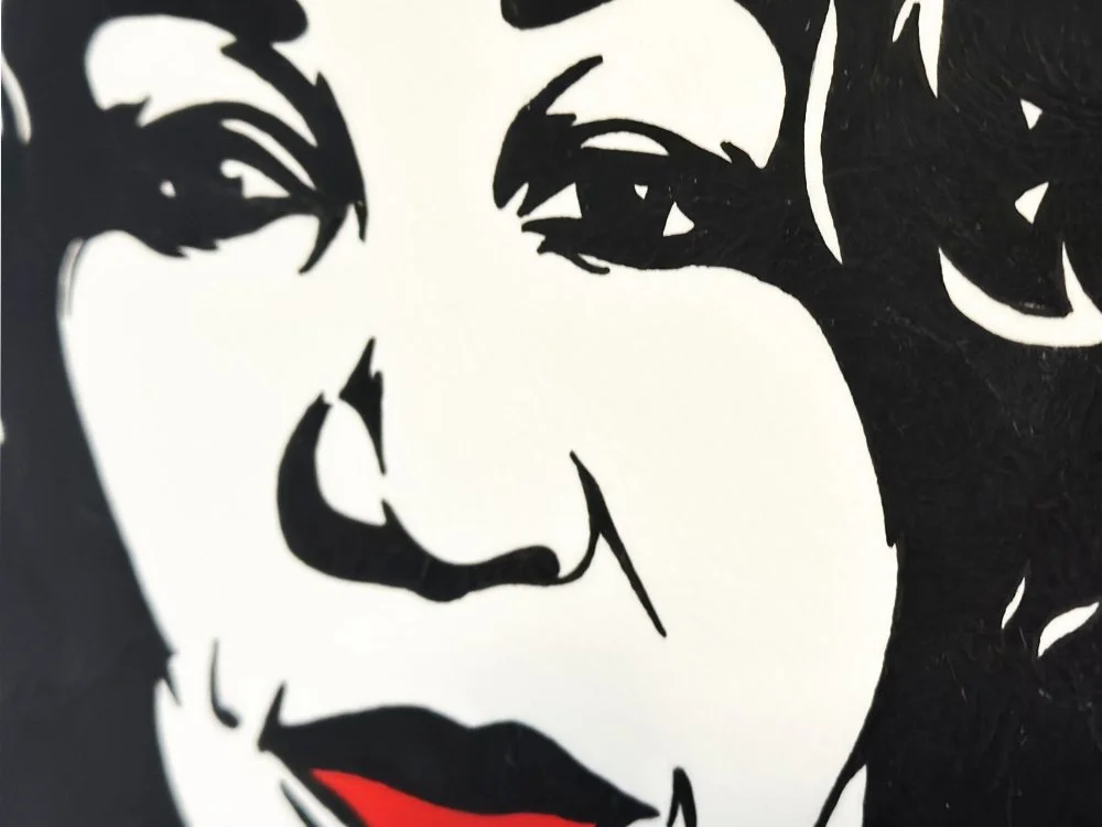 Close up detail of vibrant red lips and graphic black silhouette on archival cotton paper.