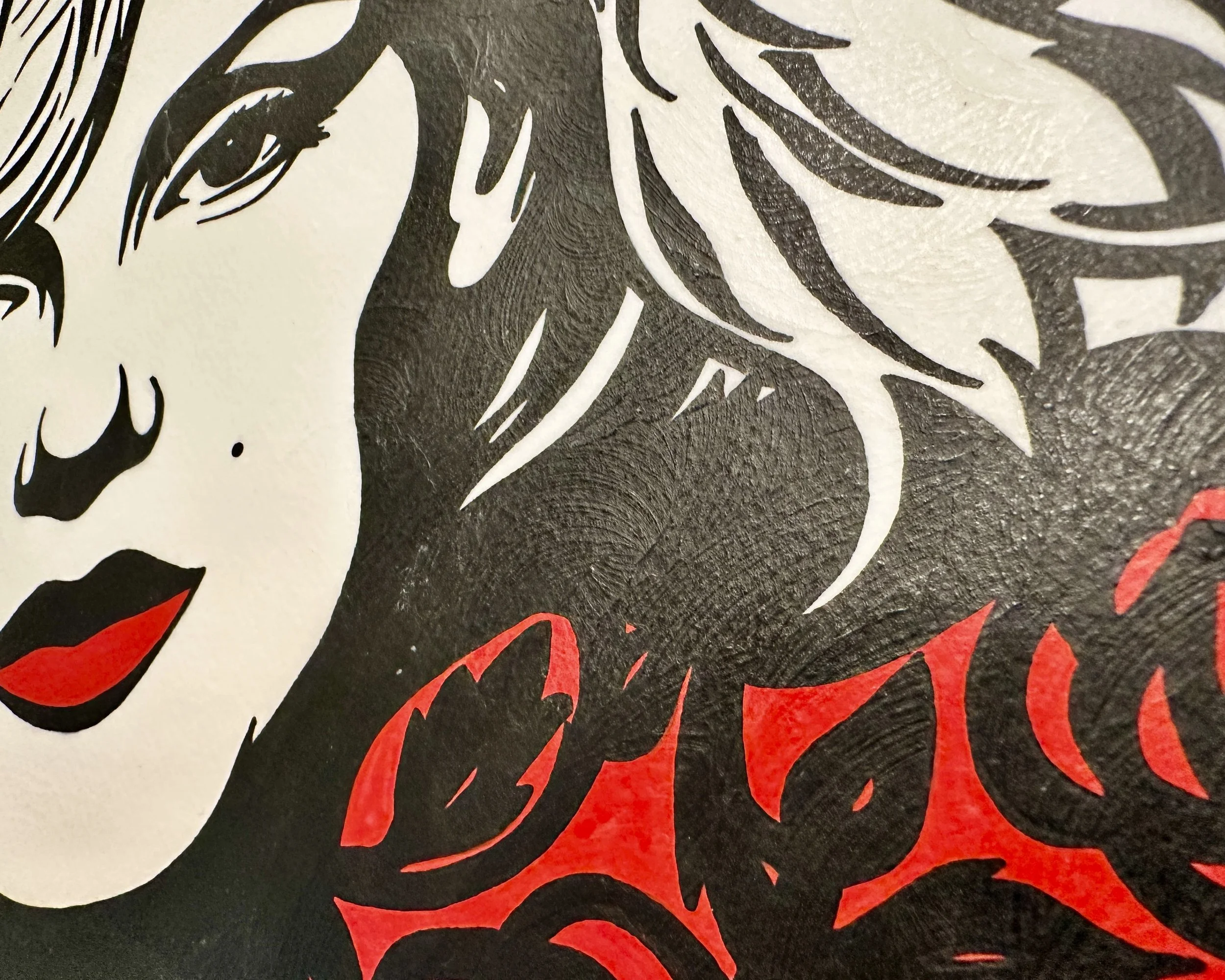 Close up detail of the intricate gold repeating geometric pattern and the signature black ribbon mark.