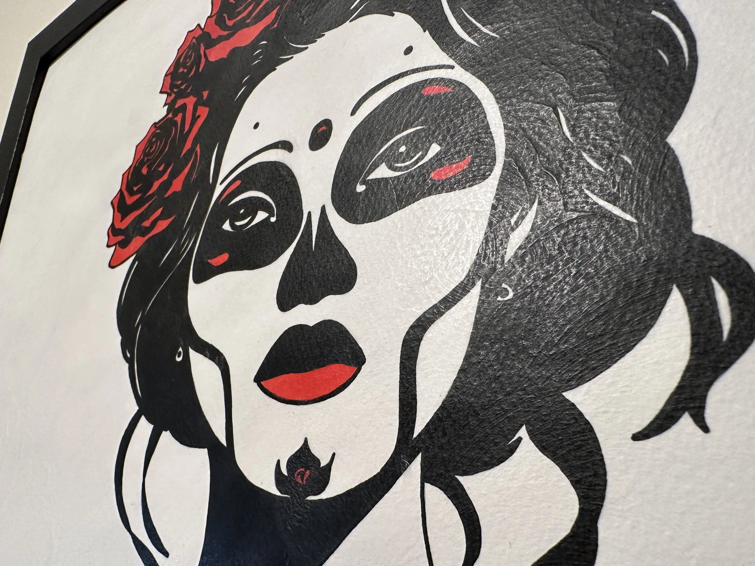 Close up detail of sugar skull makeup and a vibrant crown of red roses on a modern Day of the Dead portrait.