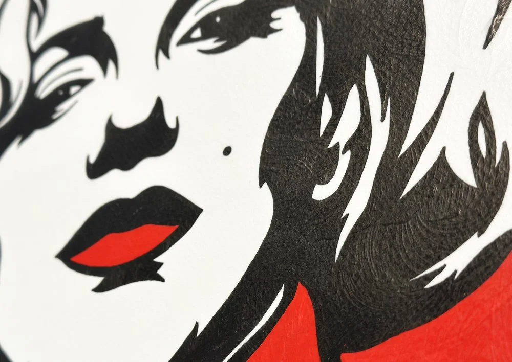 Close up detail of vibrant red lips and graphic black silhouette on archival cotton paper.