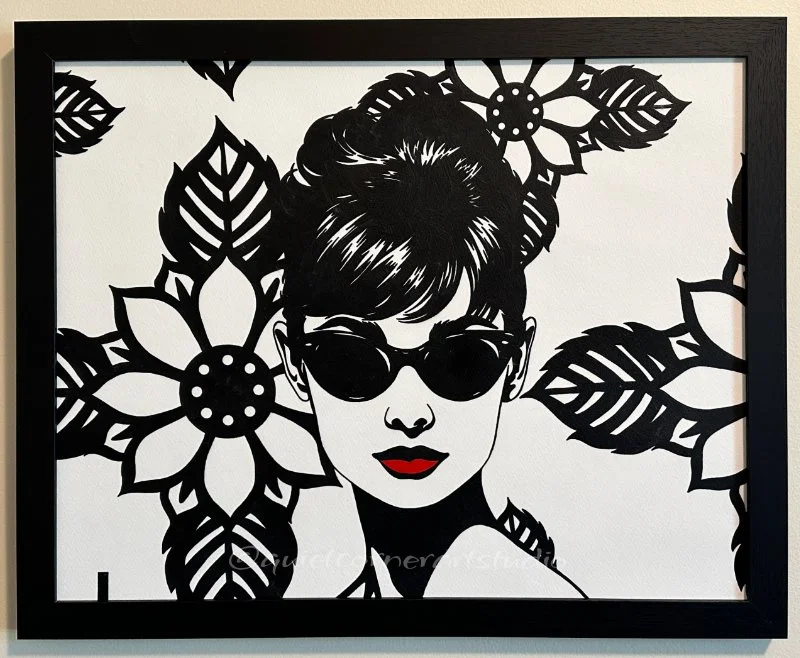 Original framed painting titled In Audrey's Footsteps featuring a pop art portrait of Audrey Hepburn with sunglasses and a floral background by Omaha artist.