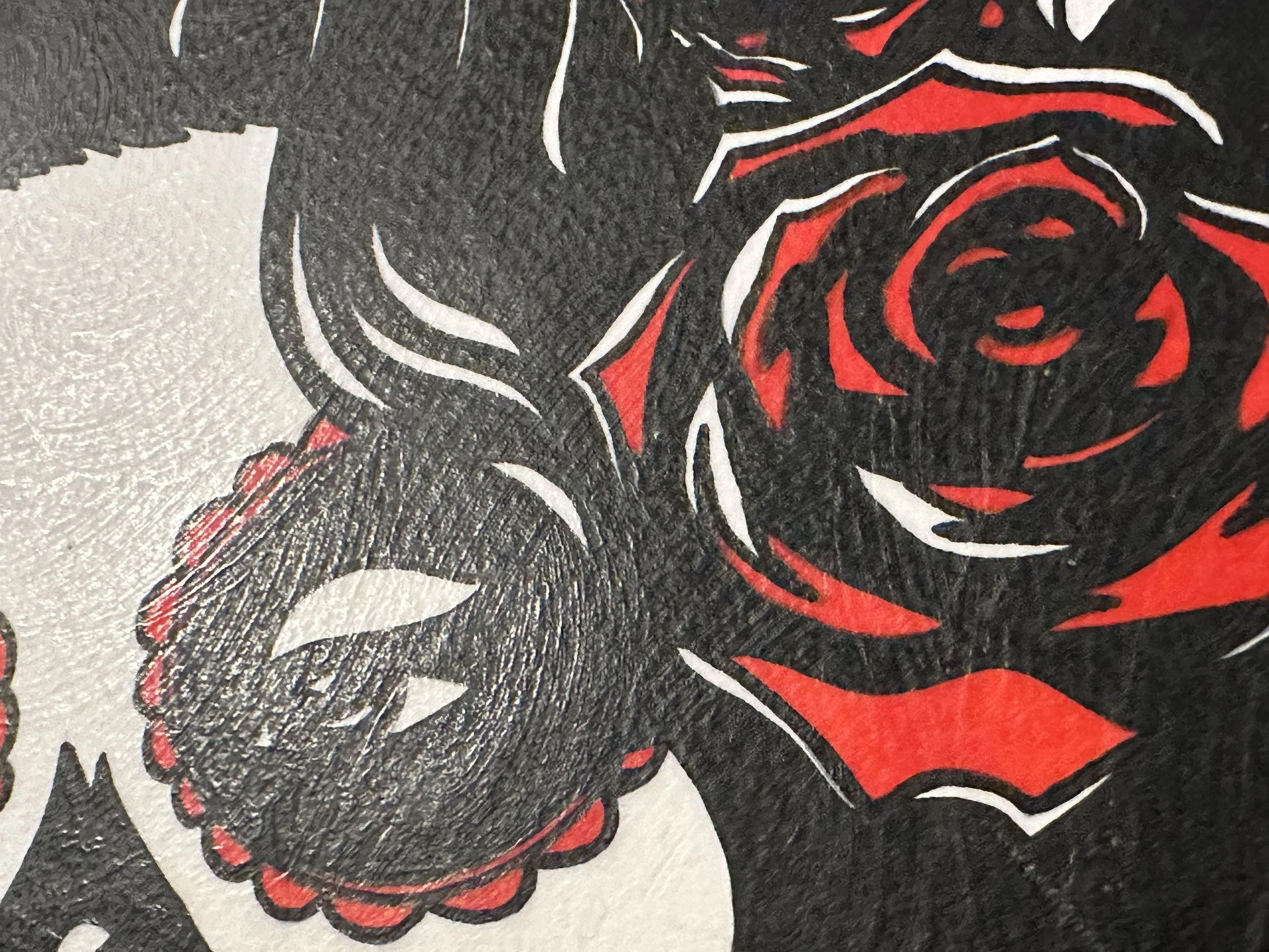 Detail shot of vibrant red roses painted in gouache against black hair on a Day of the Dead tribute painting.