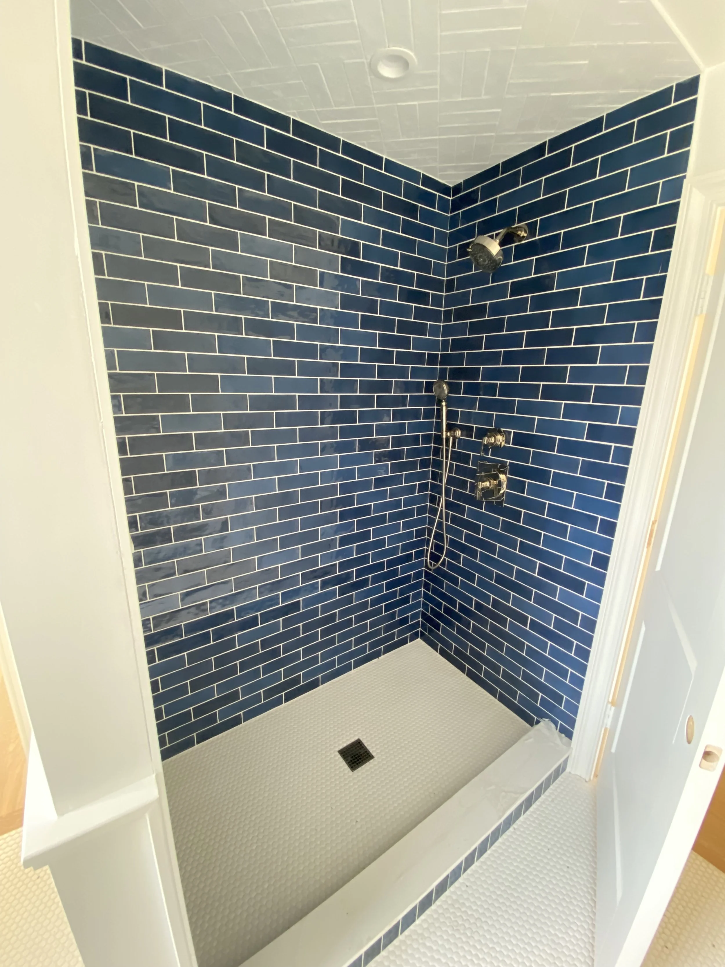 Shower with pretty blue subway tile walls