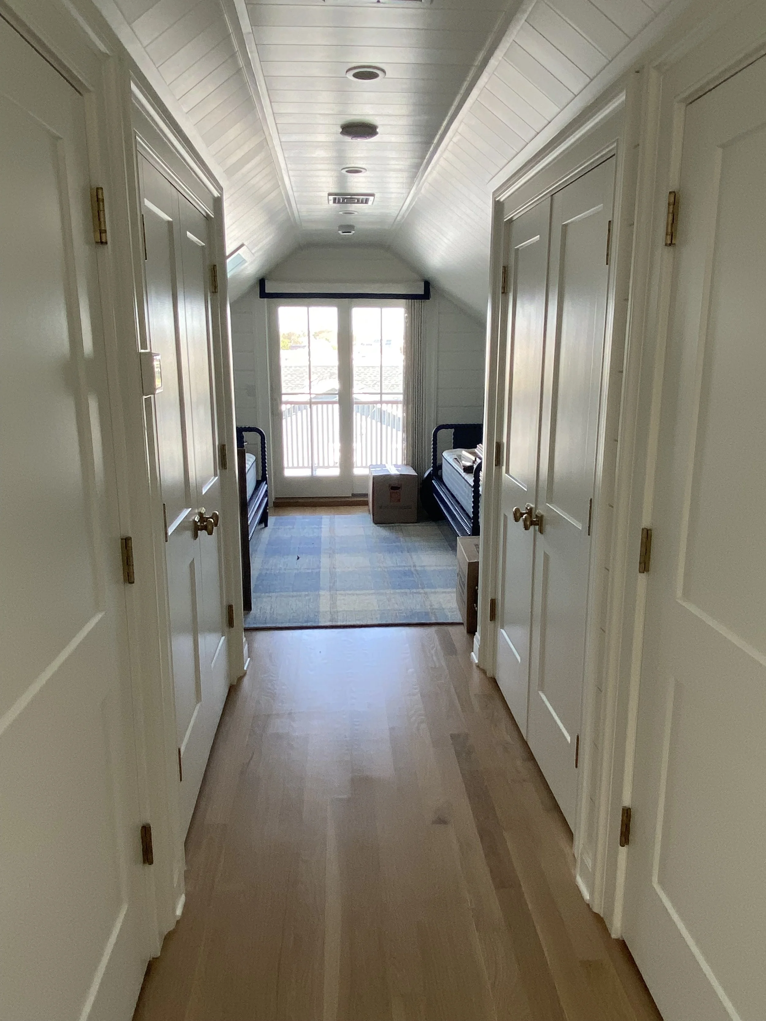 Third floor storage leading to a bedroom with a slider to a balcony overlooking the lake.