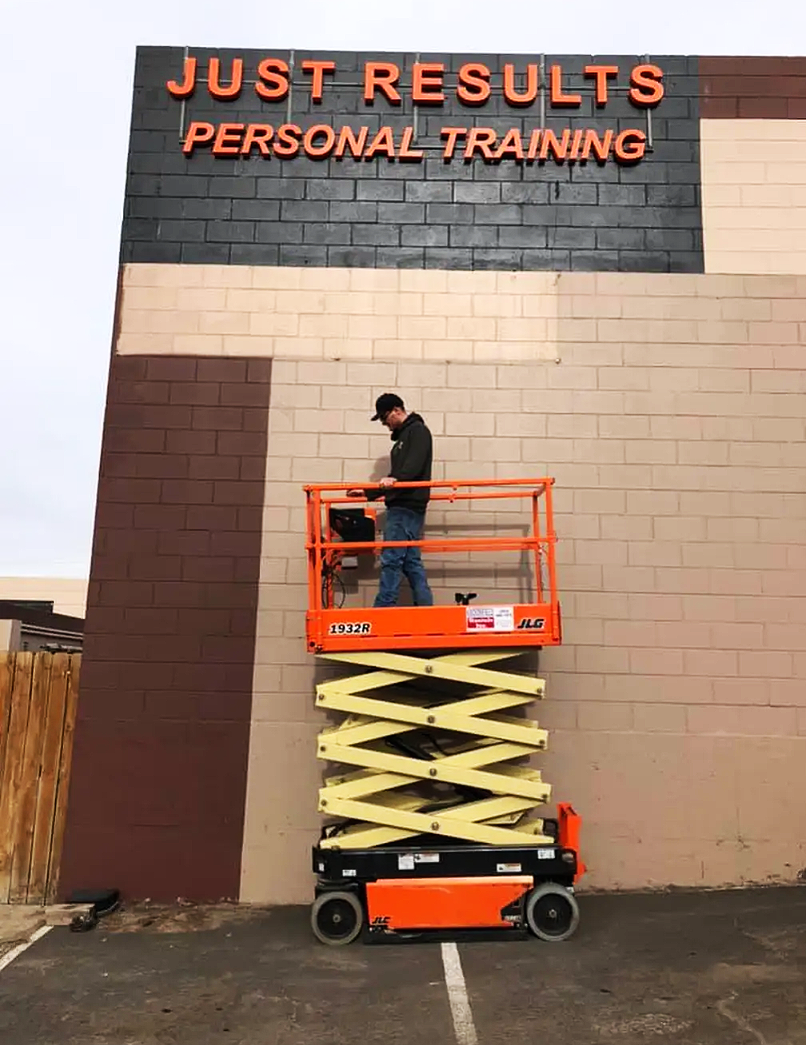 Onsite mobile welding performed from a scissor lift at a commercial property