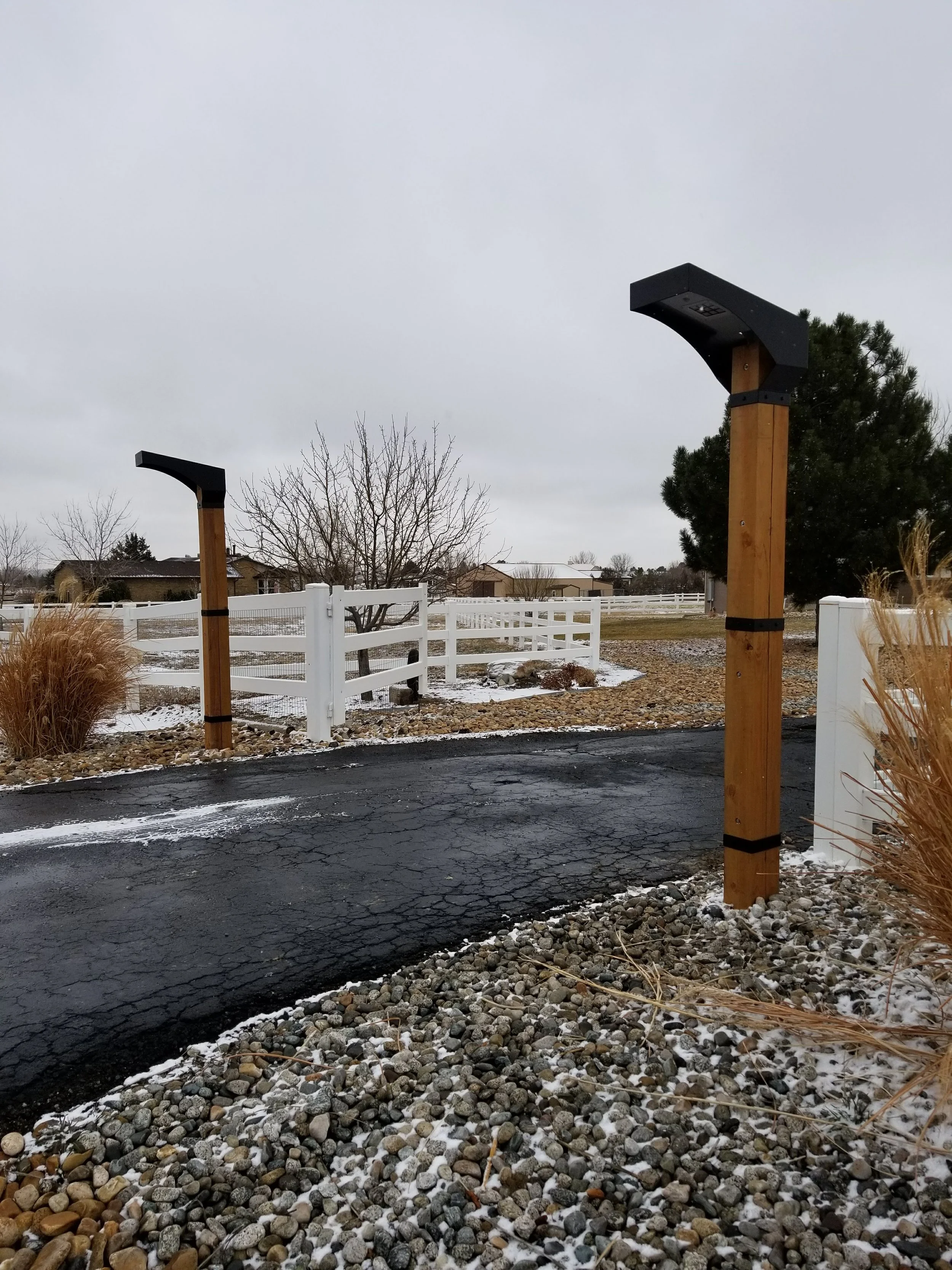 Custom steel and wood entry posts installed at residential driveway in Denver Colorado