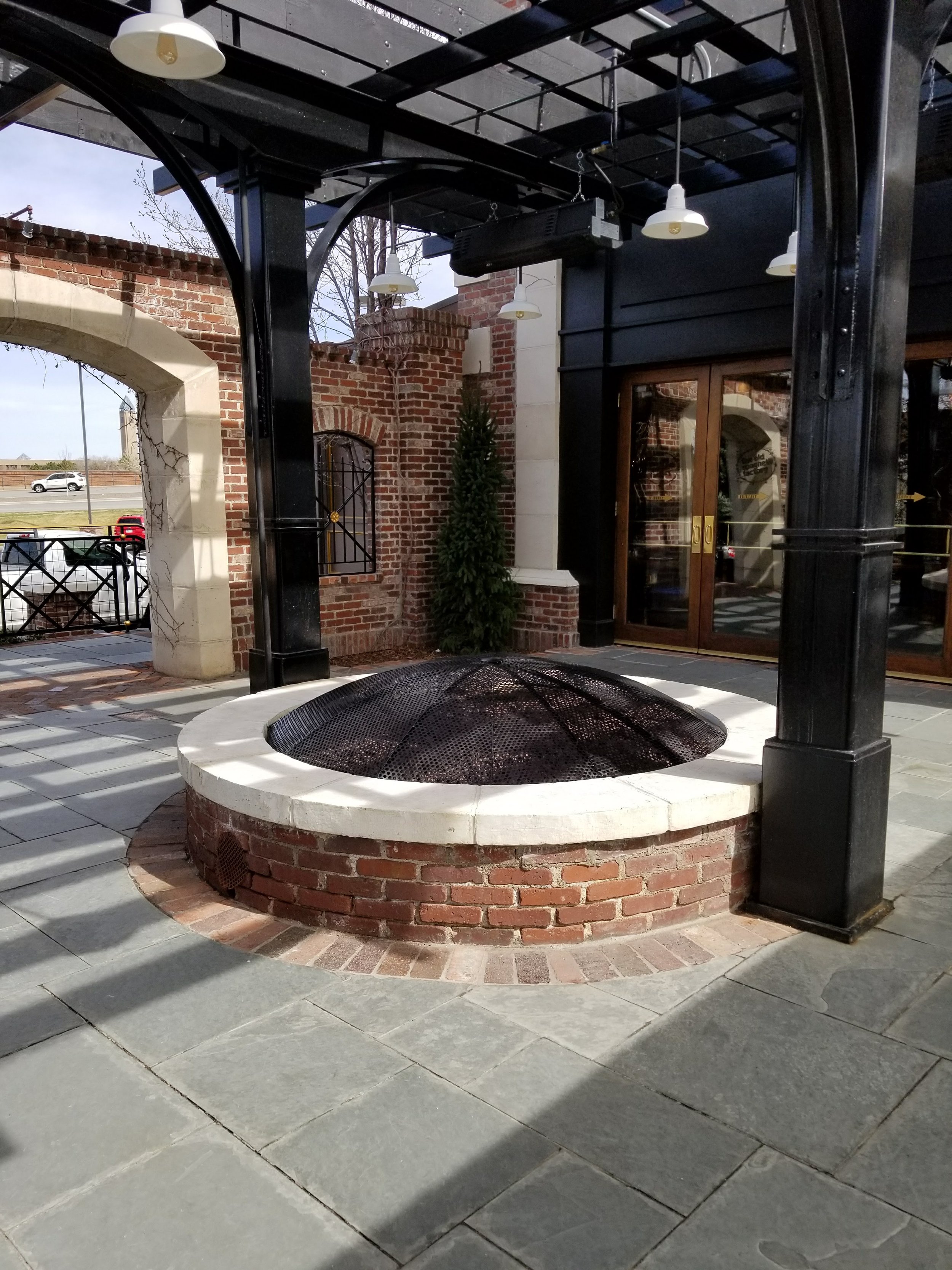 Commercial steel patio structure with welded columns and custom fire feature and fire cover in Denver