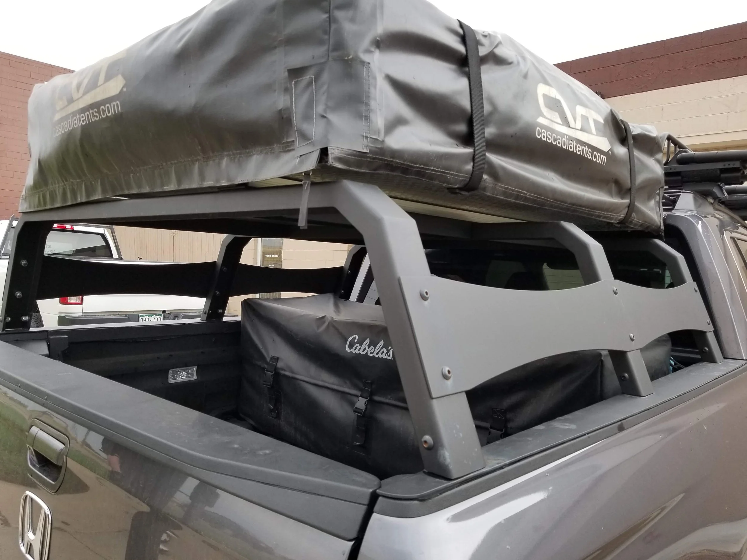 Custom fabricated steel truck bed rack supporting rooftop tent system
