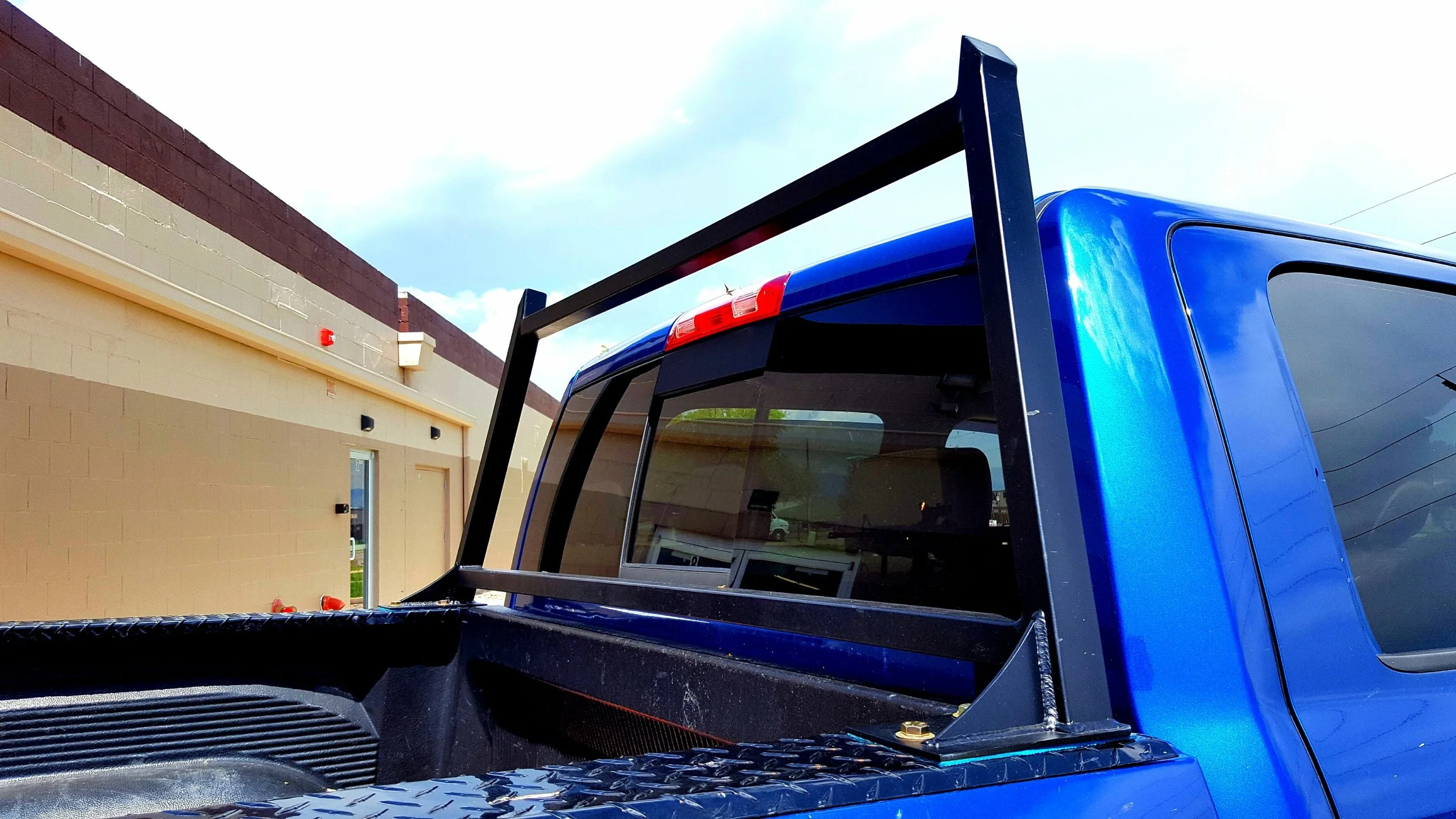 Black steel truck rack mounted to pickup bed for material transport.