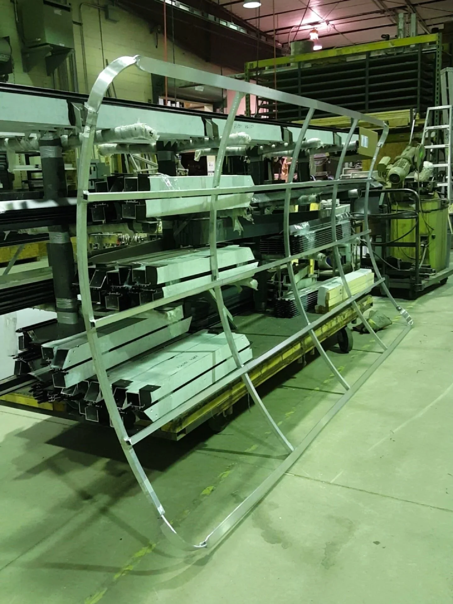 Curved aluminum frame structure assembled on shop stands with welded cross members.