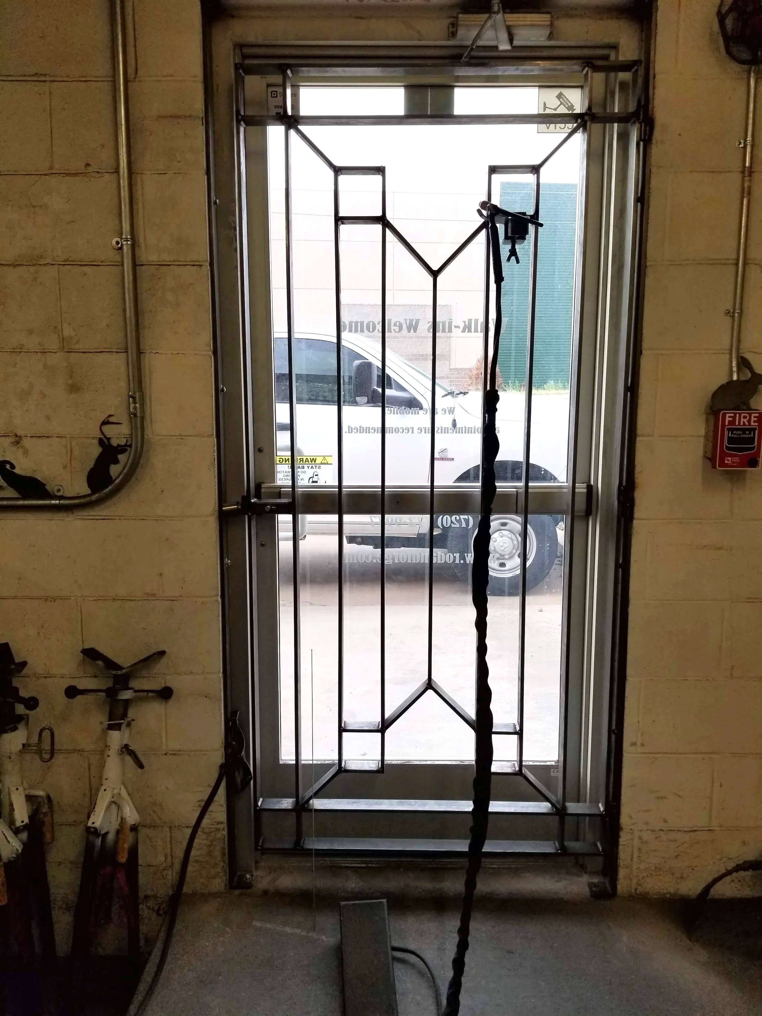 Custom fabricated steel security insert installed inside commercial glass door.