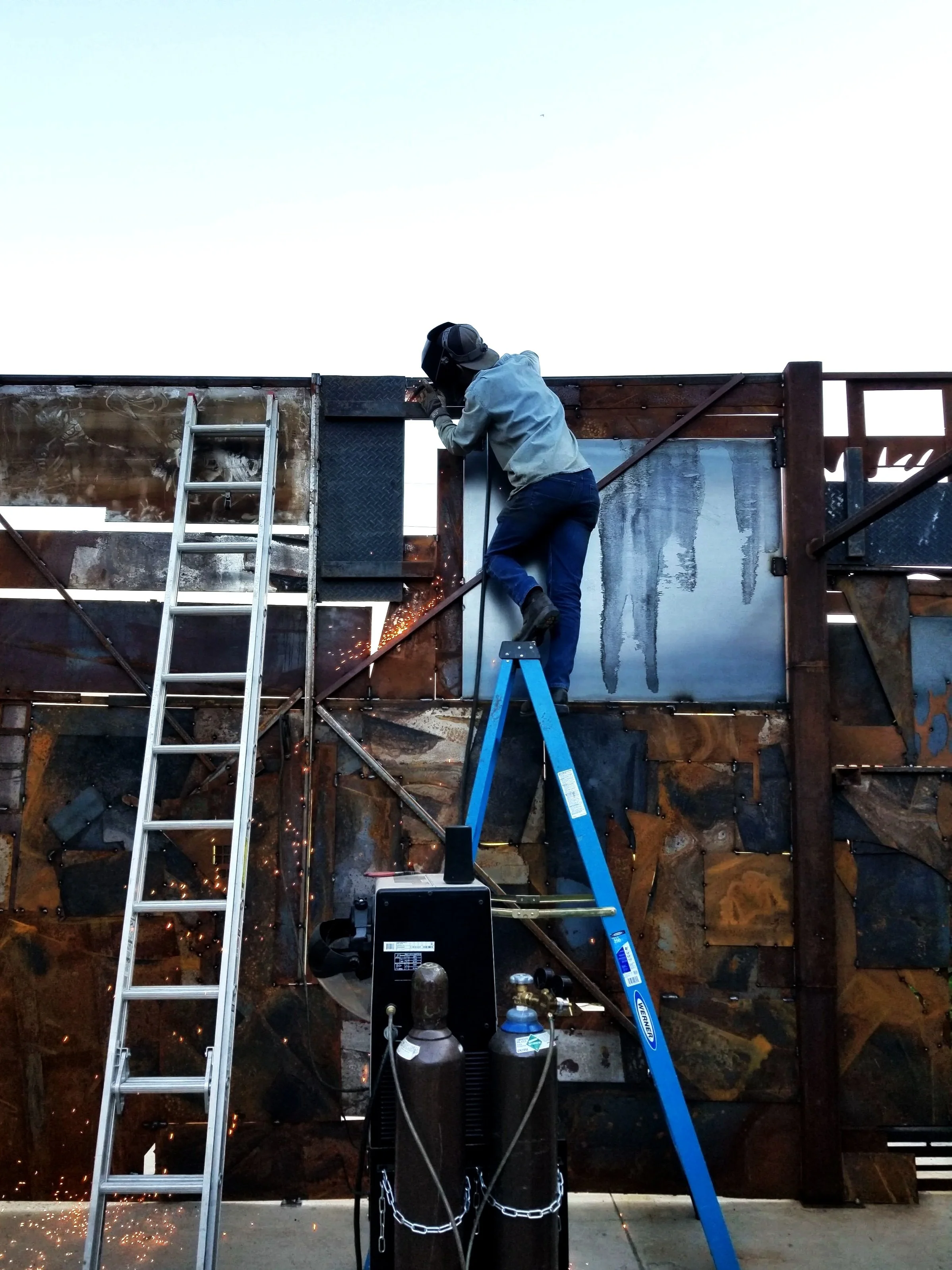 Large steel gate and structural assembly with ladder and sparks in Denver Metro